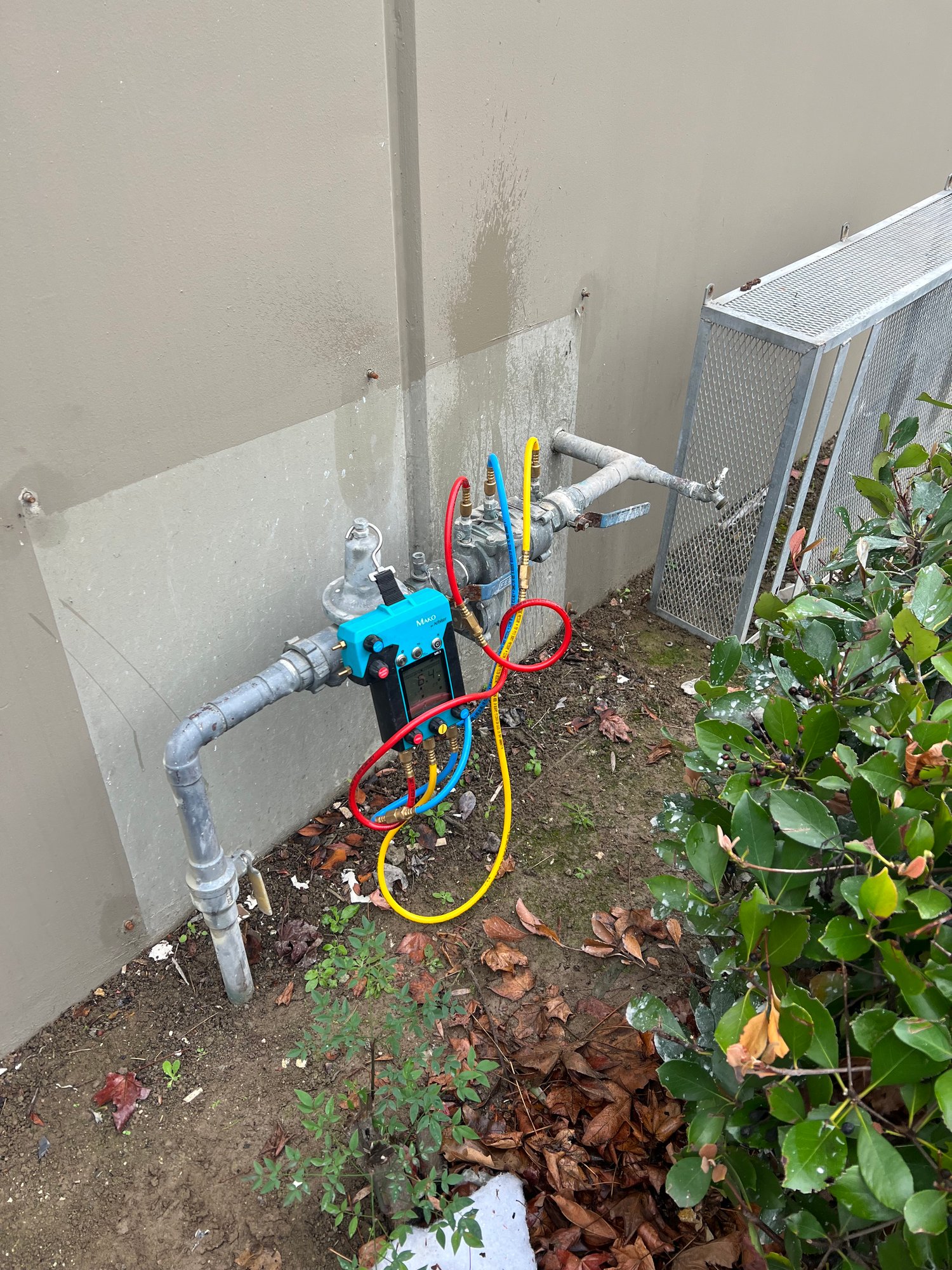 Mako digital gauge connected to backflow preventer in ground pit