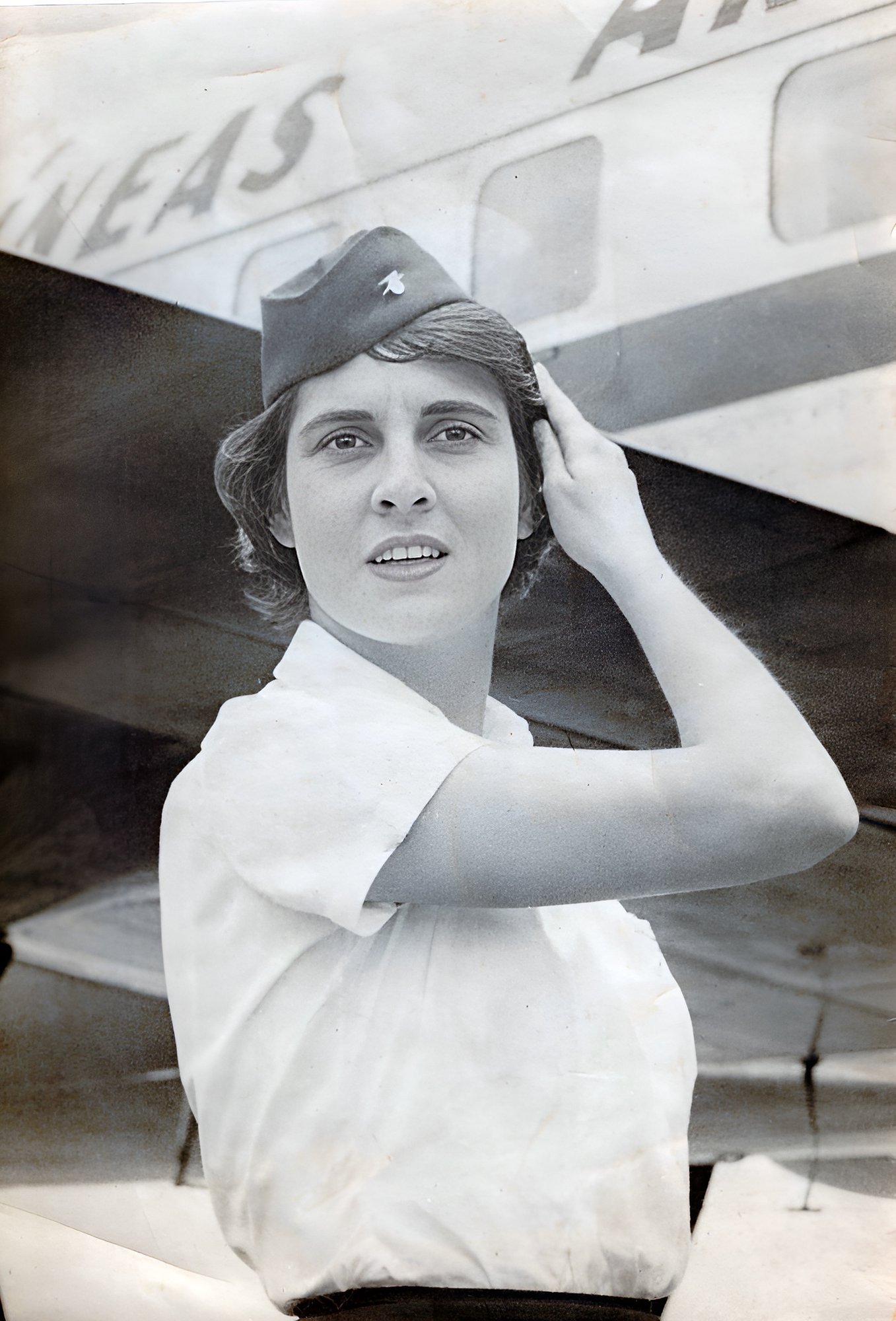Margarita jovem como aeromoça em frente ao avião