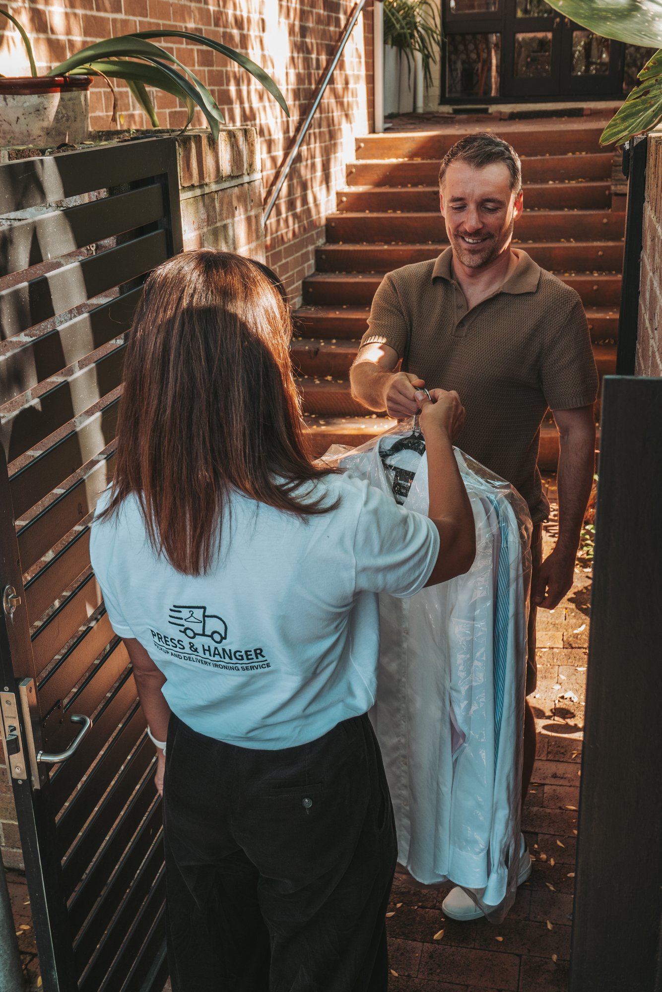 Press & Hanger staff delivering freshly pressed clothes