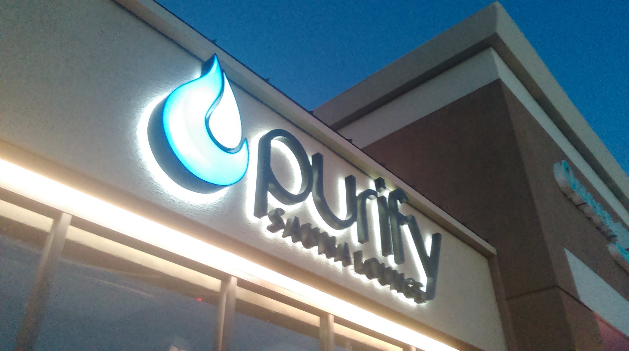 Halo-lit channel letters for Purify Sauna Lounge illuminated at night in Orange County