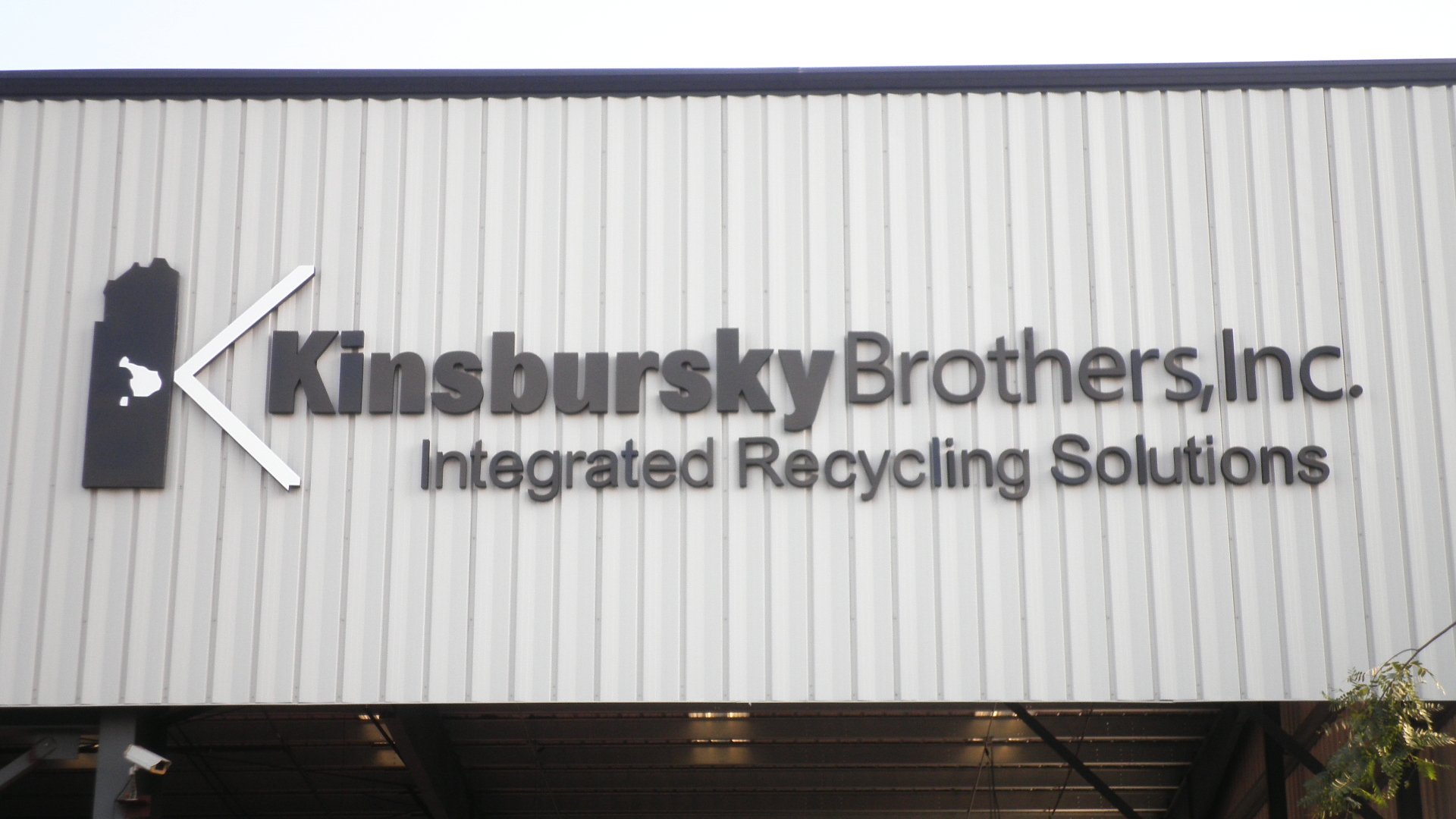 Large dimensional aluminum letters on corrugated metal industrial warehouse facade