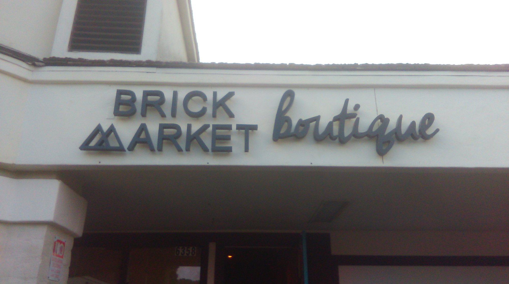 Dimensional building letters on white retail boutique exterior