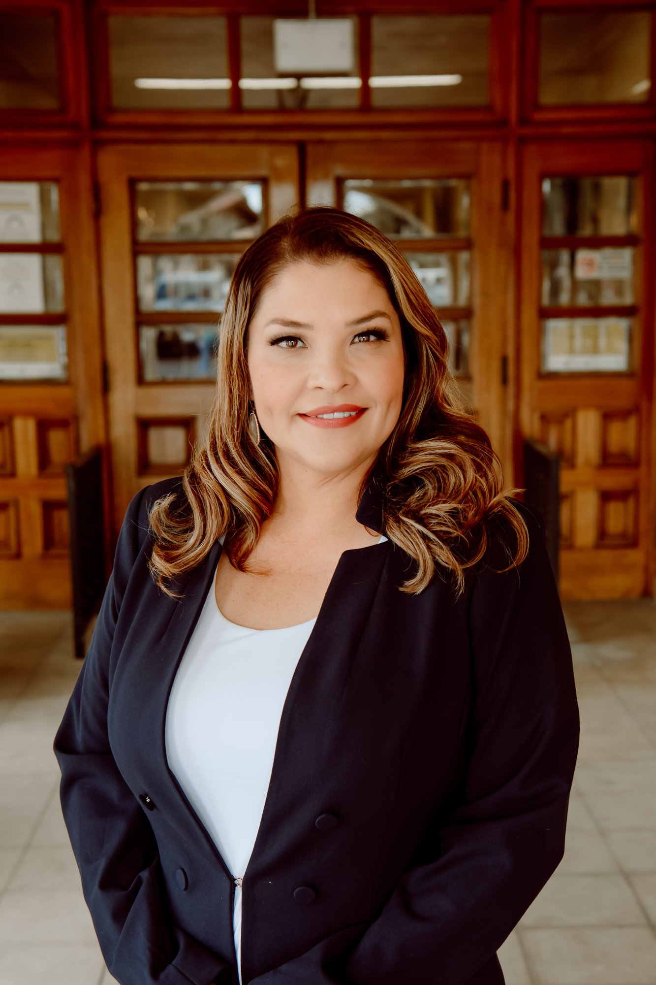 Maribel Aguilera in blue suit at courthouse with brown doors