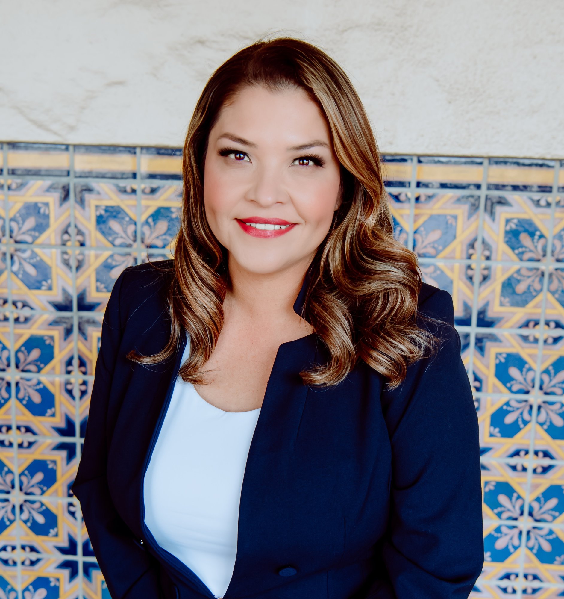Maribel Aguilera in blue suit with tiled background
