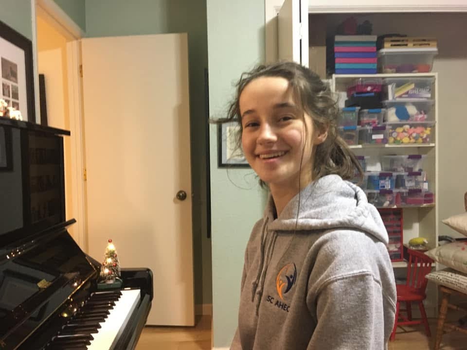 Teen student smiling at the piano