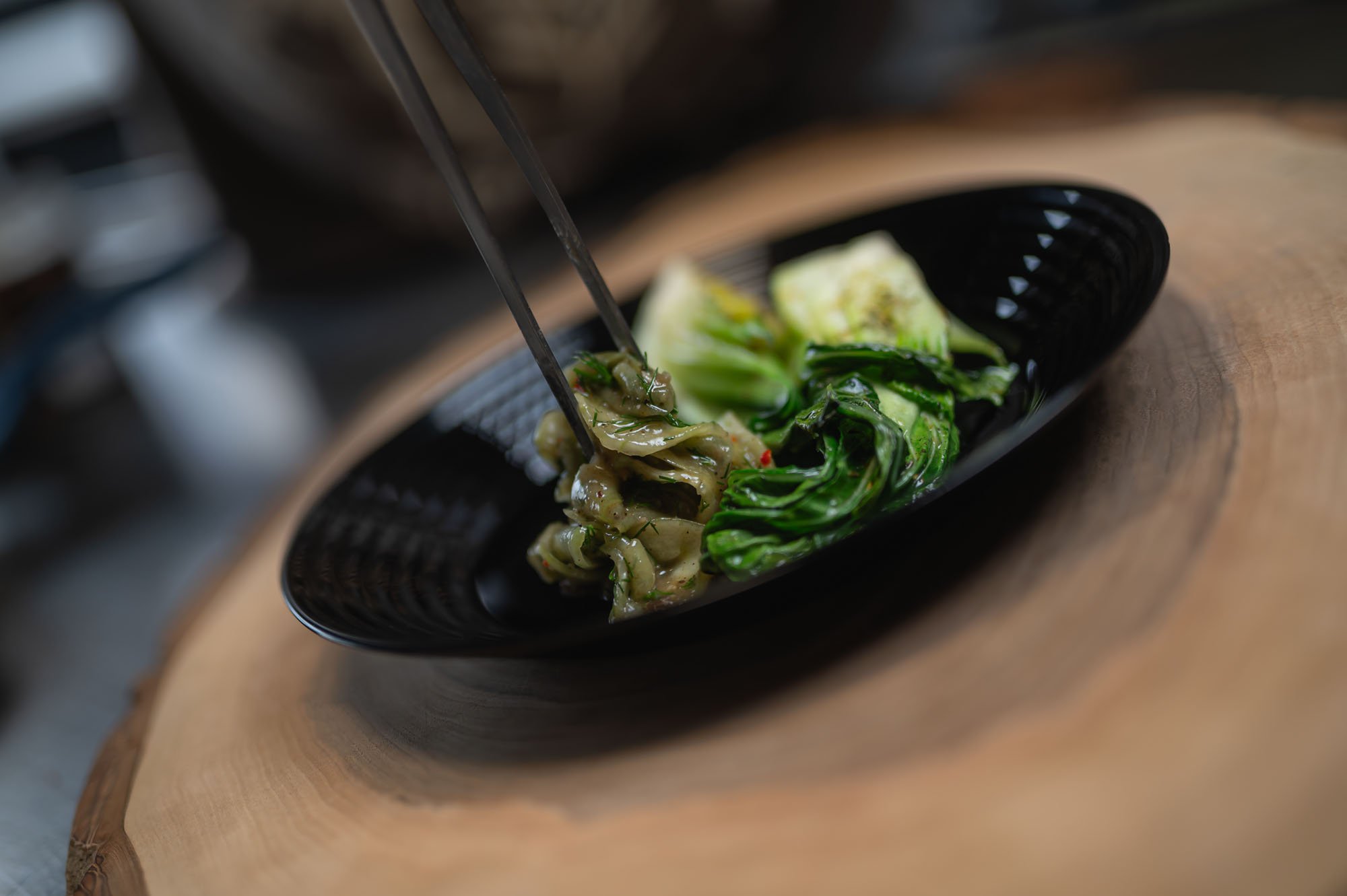 Pak choi kladený na tanier kliešťami