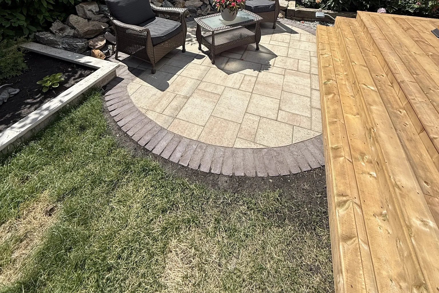 Curved paver patio with cedar deck and firepit seating area, Calgary