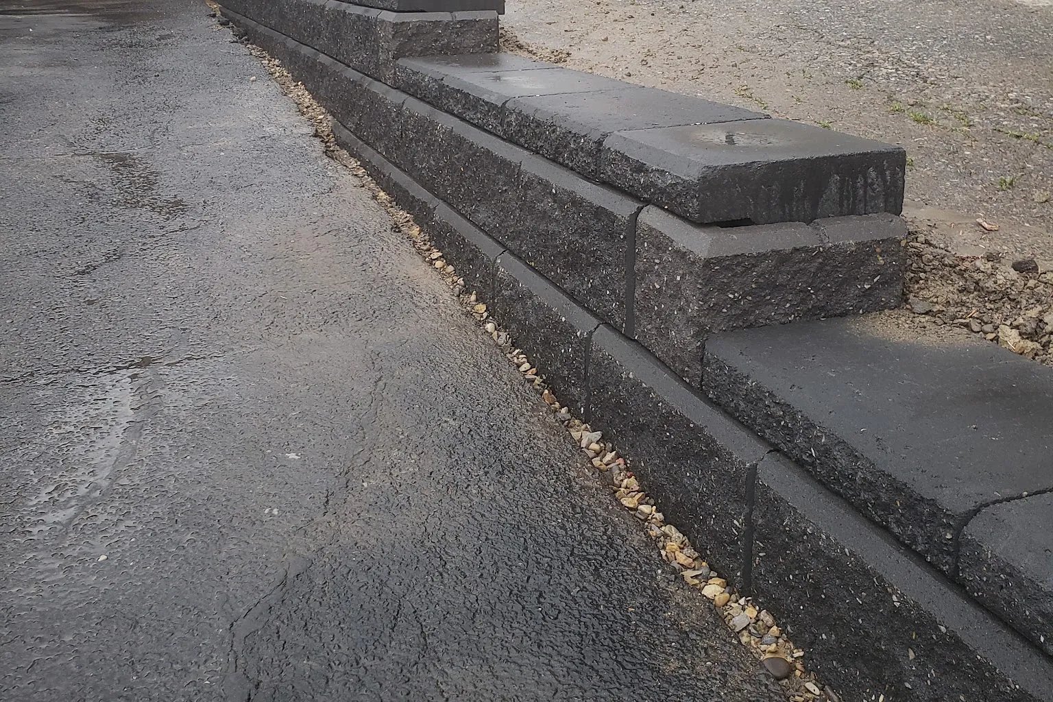 Charcoal stone curb edging against asphalt, Calgary hardscaping detail by All The Moore