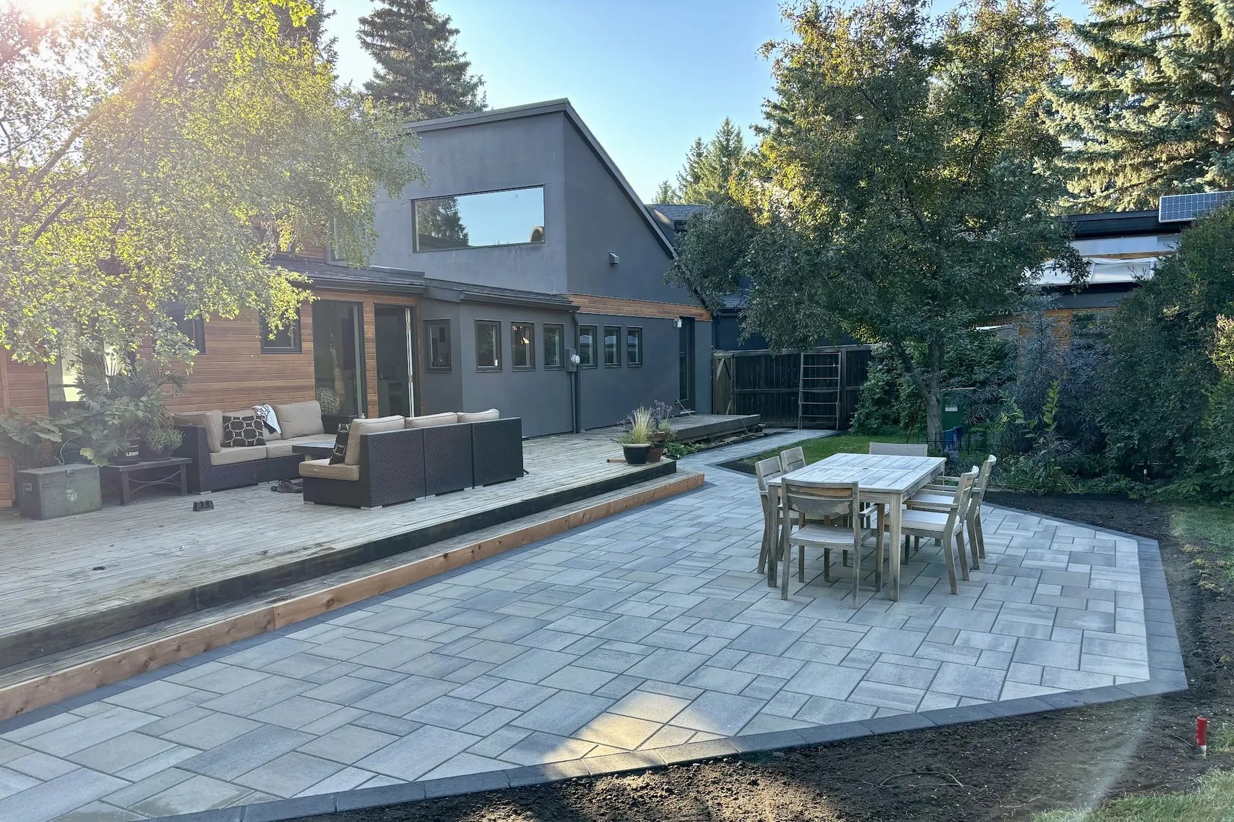 Aerial drone view of completed paver patio with sectional and dining set, Calgary