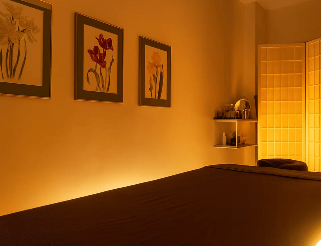 Interiér masážního studia Le Massage – masážní stůl, teplé světlo, Praha Holešovice