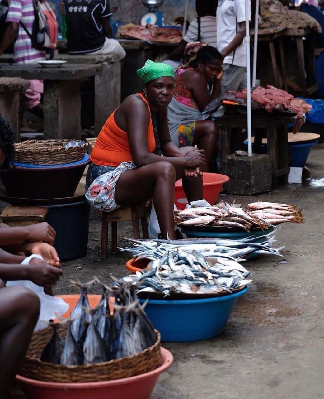 Uma mulher a vender peixe fresco numa banca de mercado na cidade de São Tomé