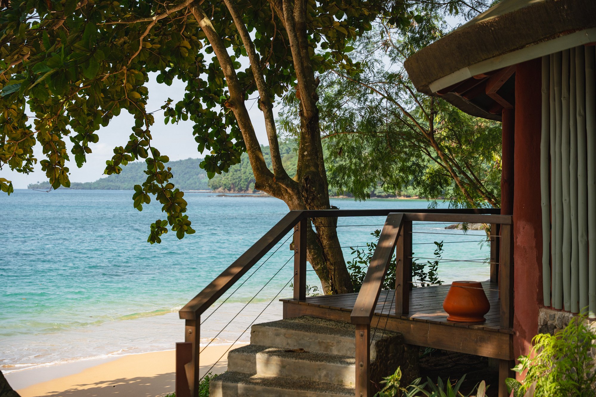 Bungalow terrace with steps leading down to the sandy beach at Bom Bom