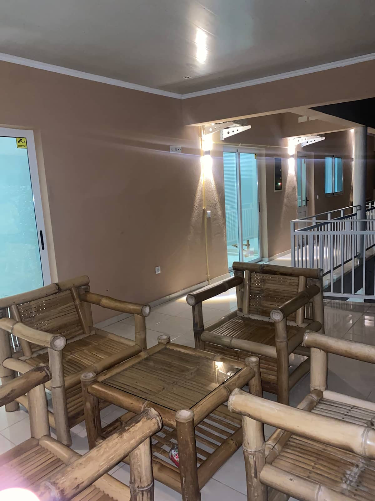 Evening view of the covered outdoor lounge with bamboo seating at Residencial Bigasso