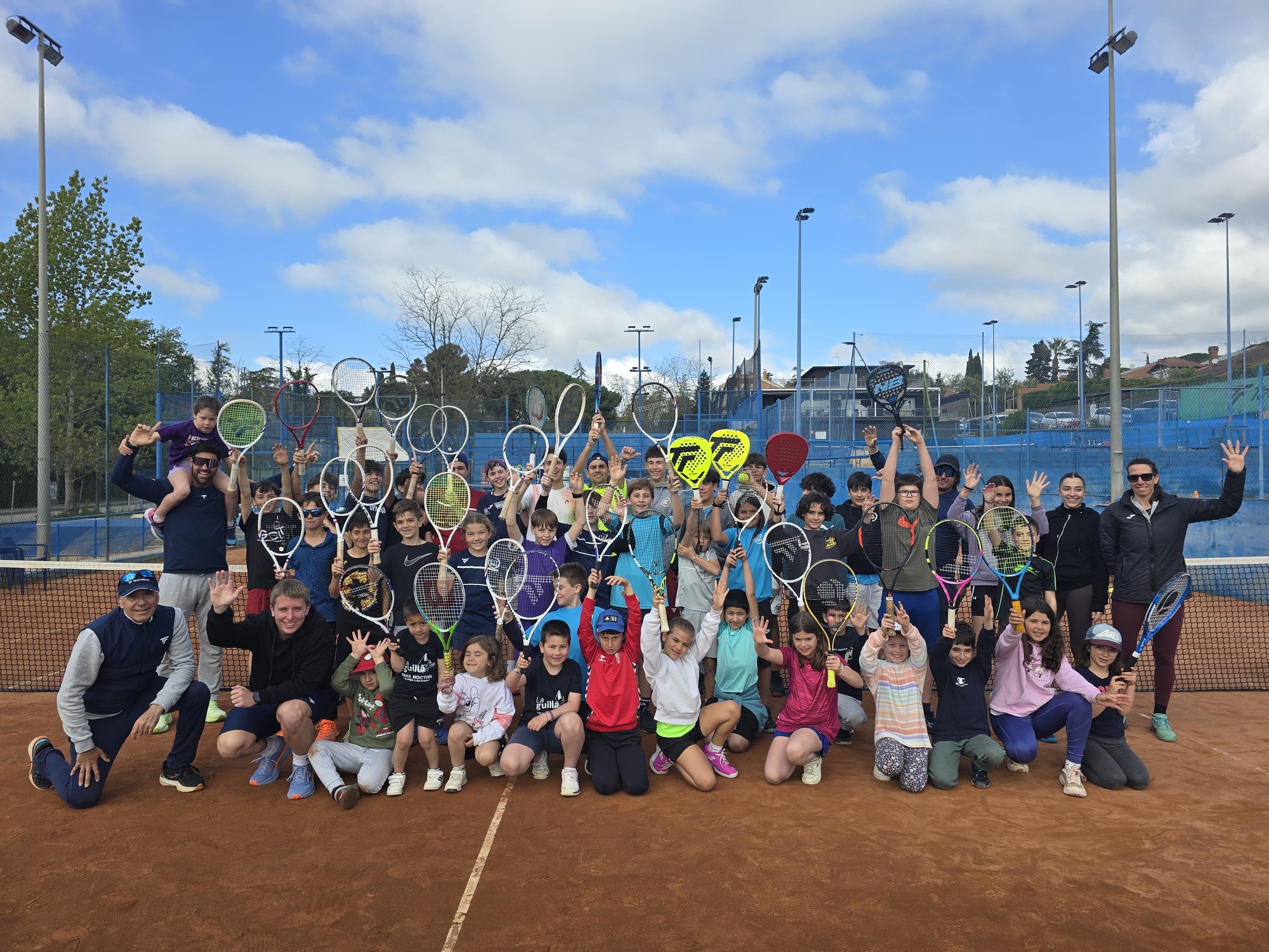 Escola de tennis City Sports – grup d'alumnes i monitors amb raquetes a la pista