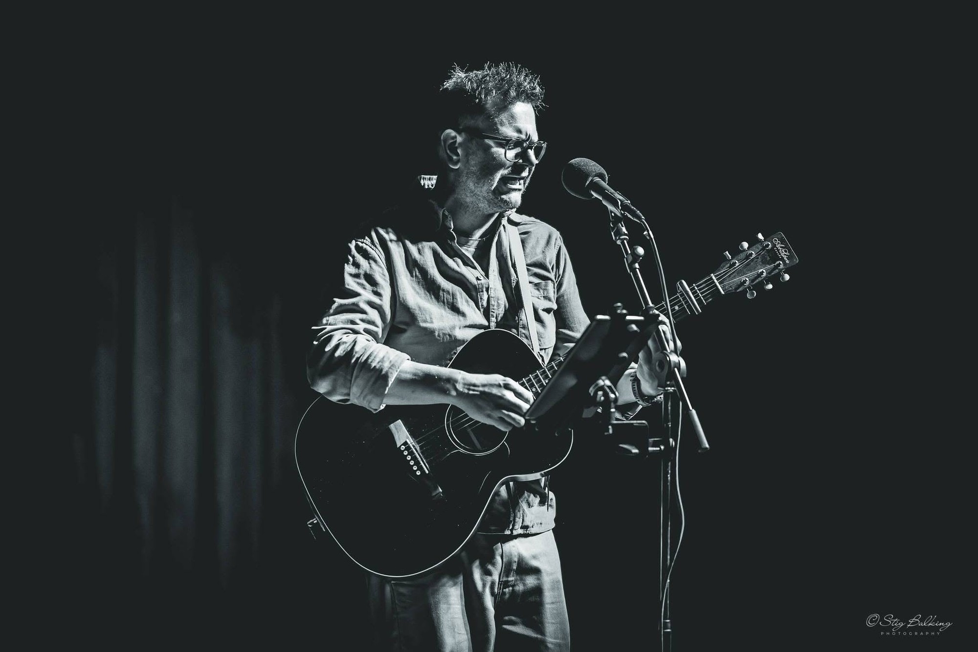 Søren synger og spiller guitar ved mikrofonen