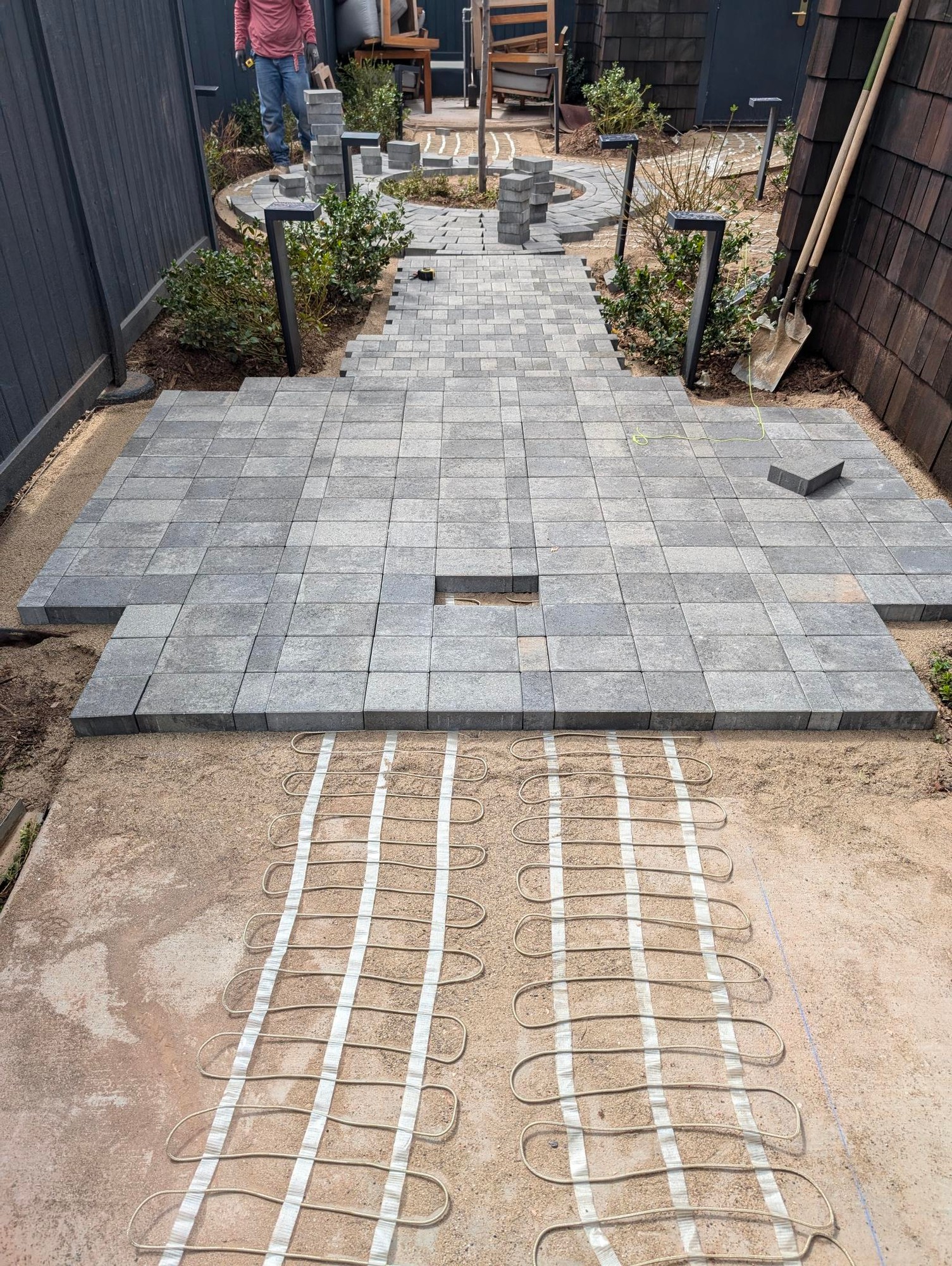 Overhead view of heating cable installation under paver walkway and patio