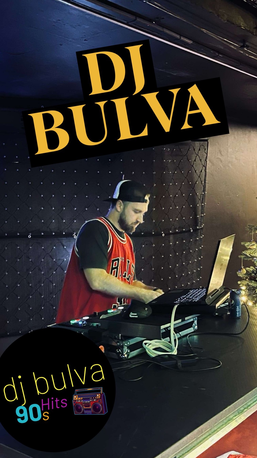 DJ BULVA za DJ pultem s neonovým logem