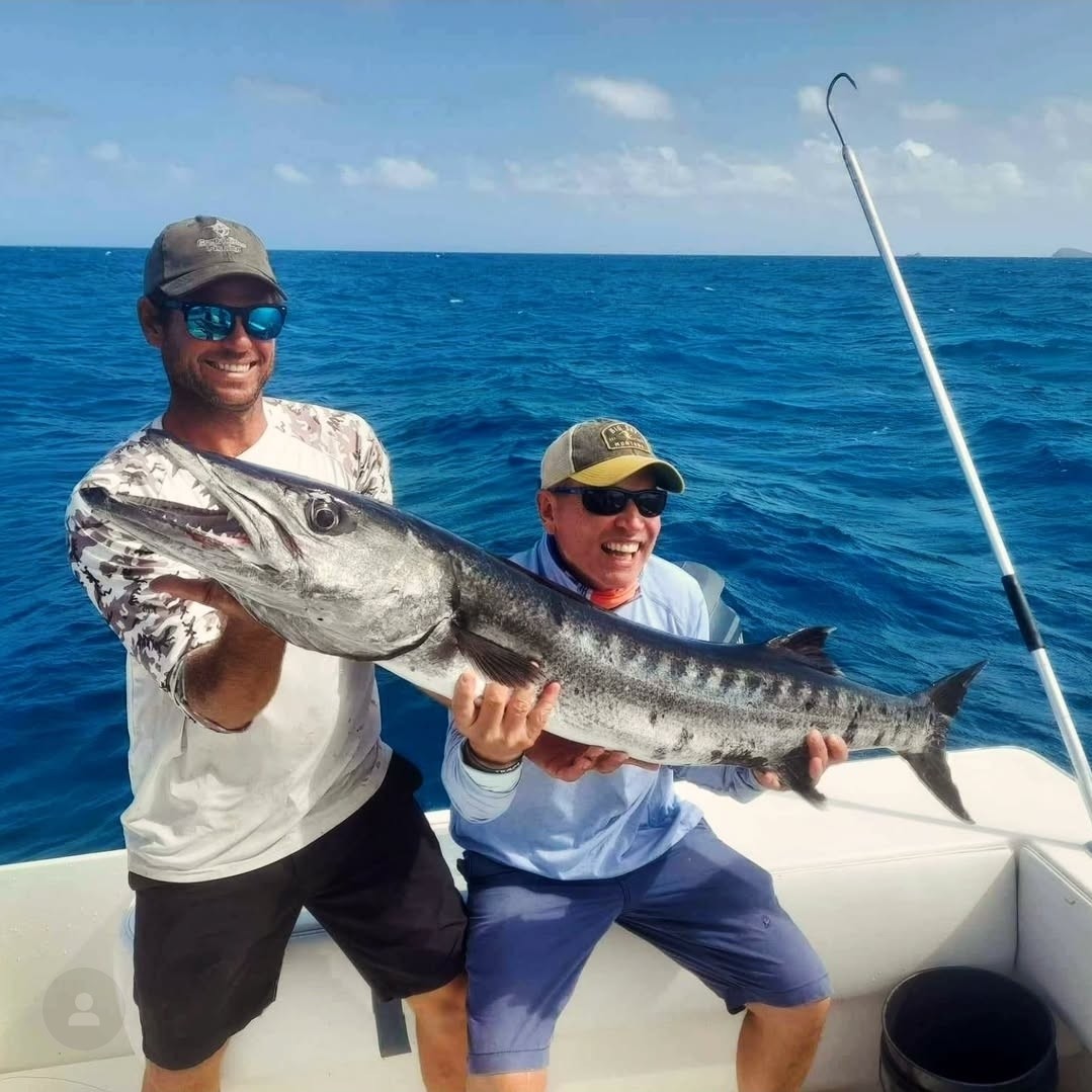 Anglers with a big barracuda caught while trolling