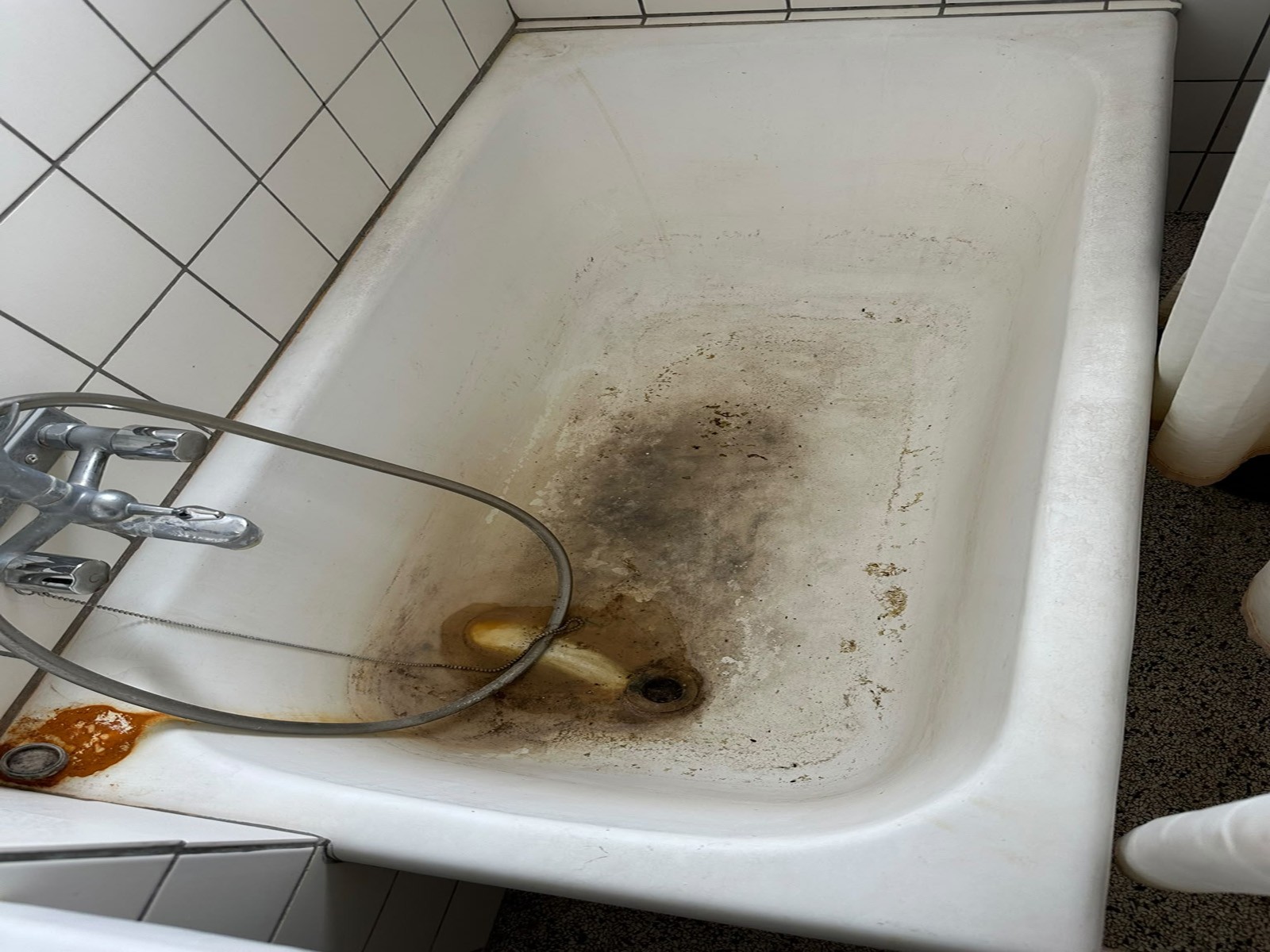 Badekar med kraftige kalkaflejringer før grundig afkalkning i Aarhus