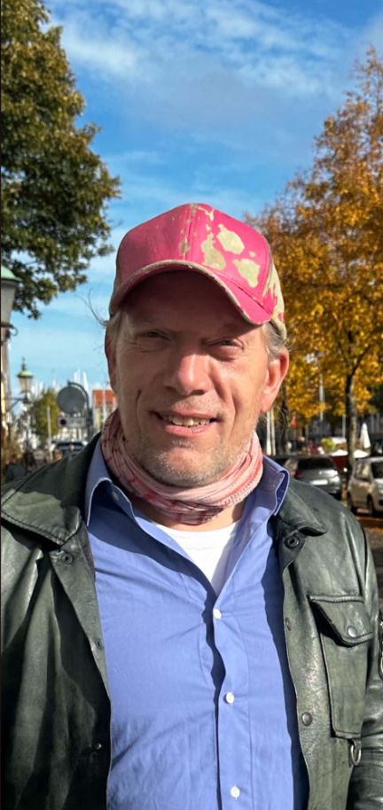 Portræt af Jens Stardust med lyserød kasket på en efterårsgade