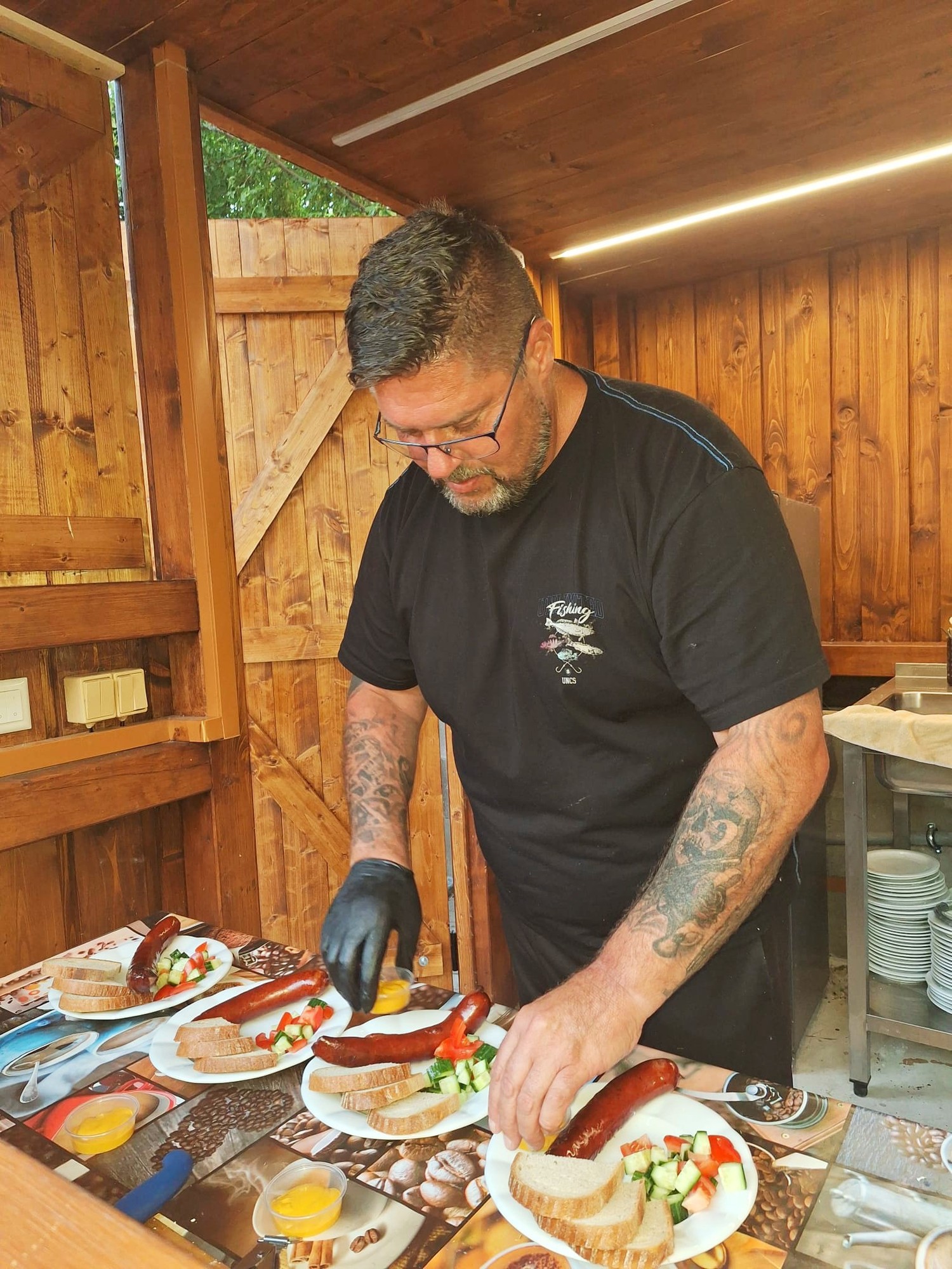 Příprava grilu – celý kuchař s čerstvými klobásami a špekáčky
