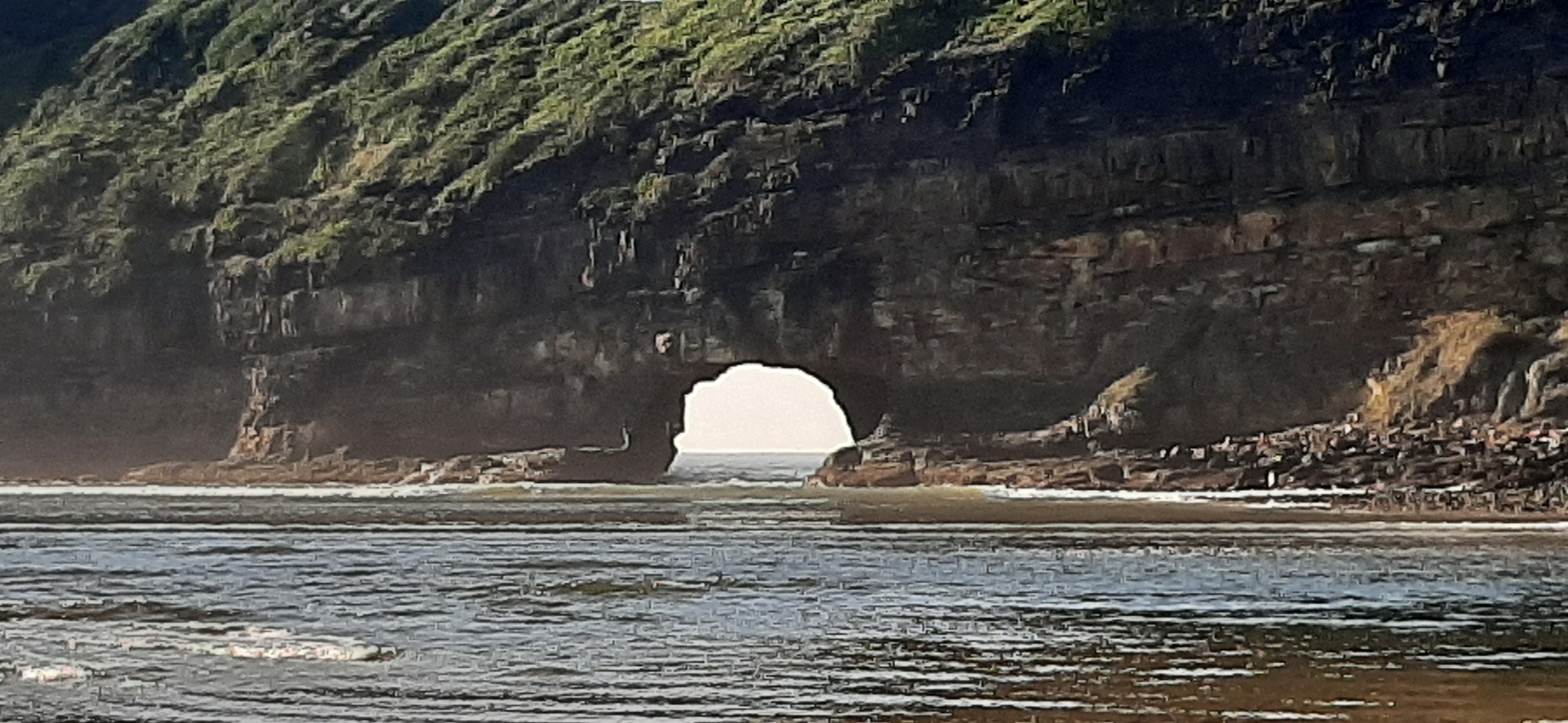 The actual 'hole' — waves crash through the ancient arch in the cliff face