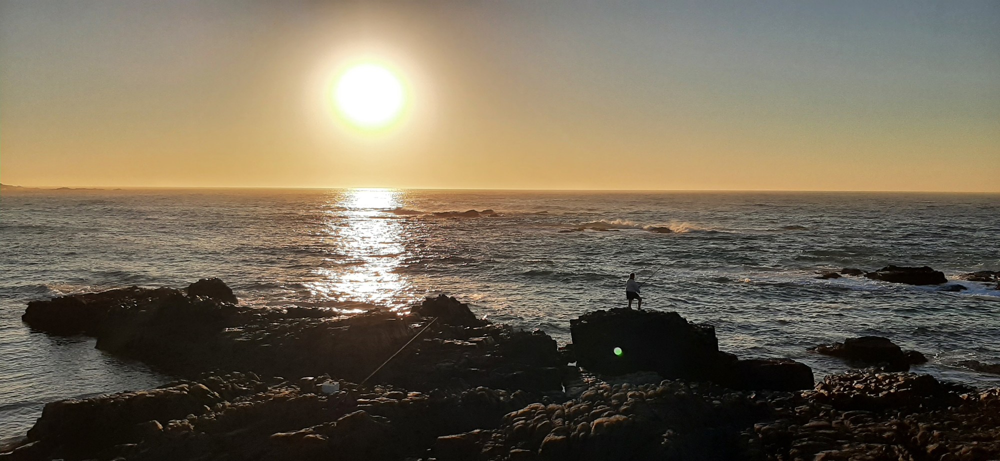 Early-morning fishing off the rocks at sunrise