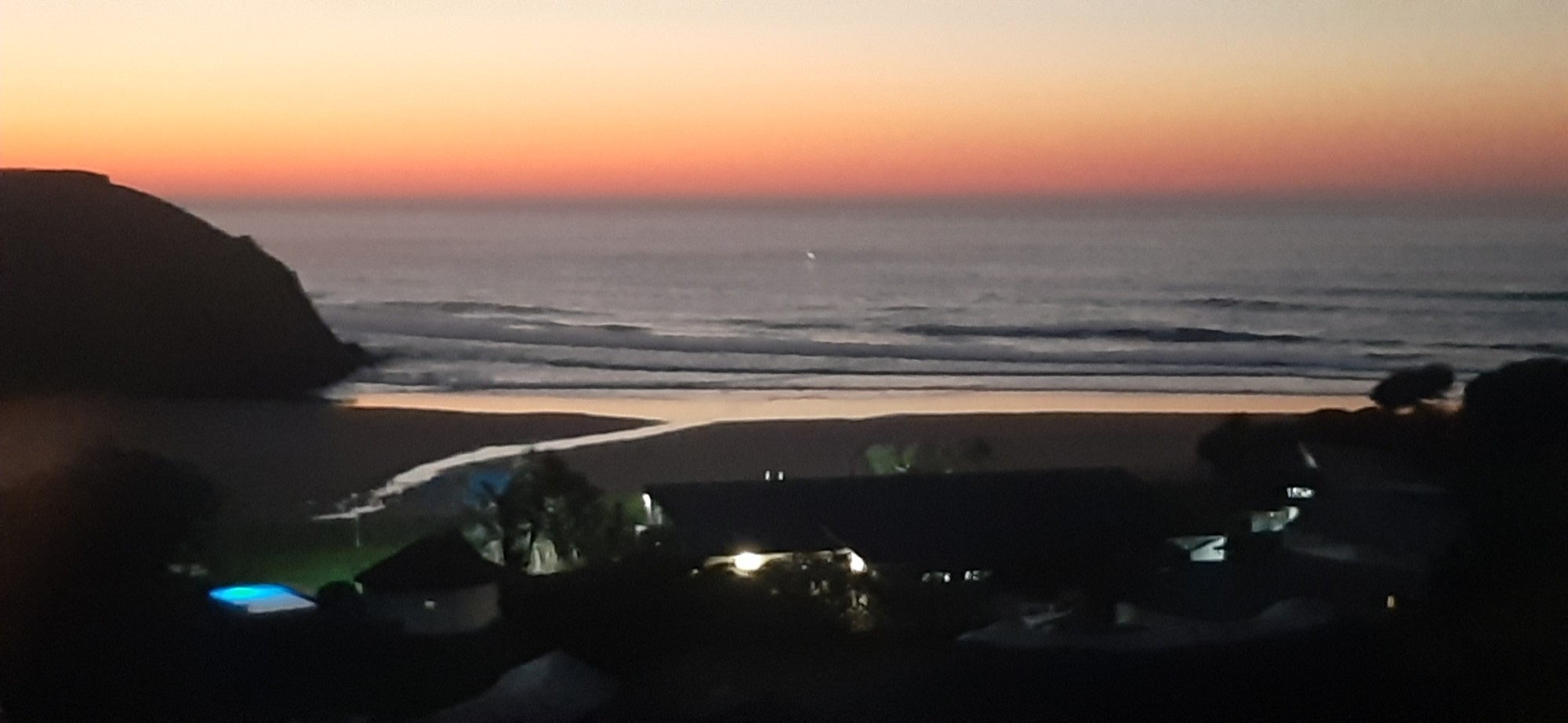 After sunset — resort lights flicker on as the horizon glows orange