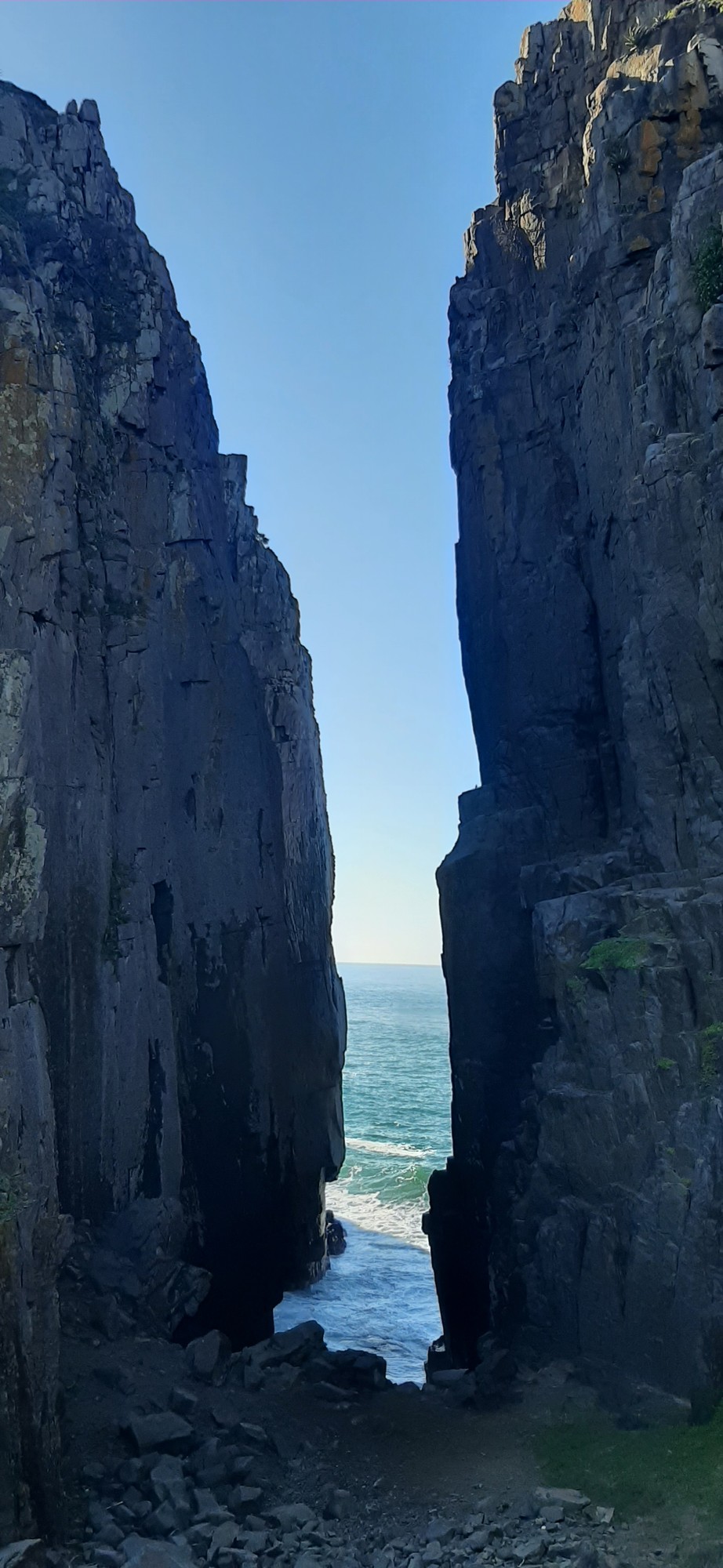 Through the slot — the ocean glimpsed through the narrow cliff crack