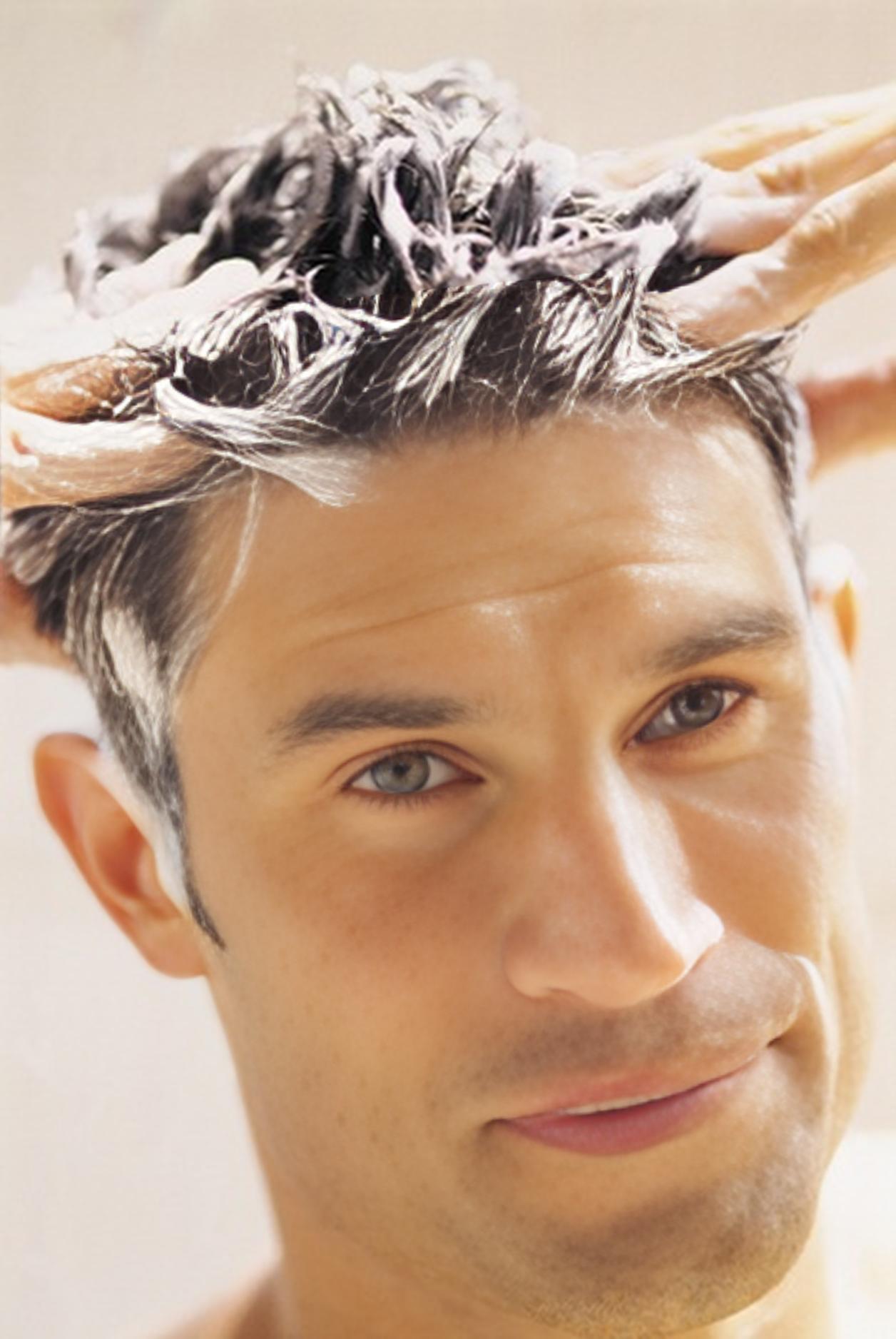 Homem lavando o cabelo com shampoo