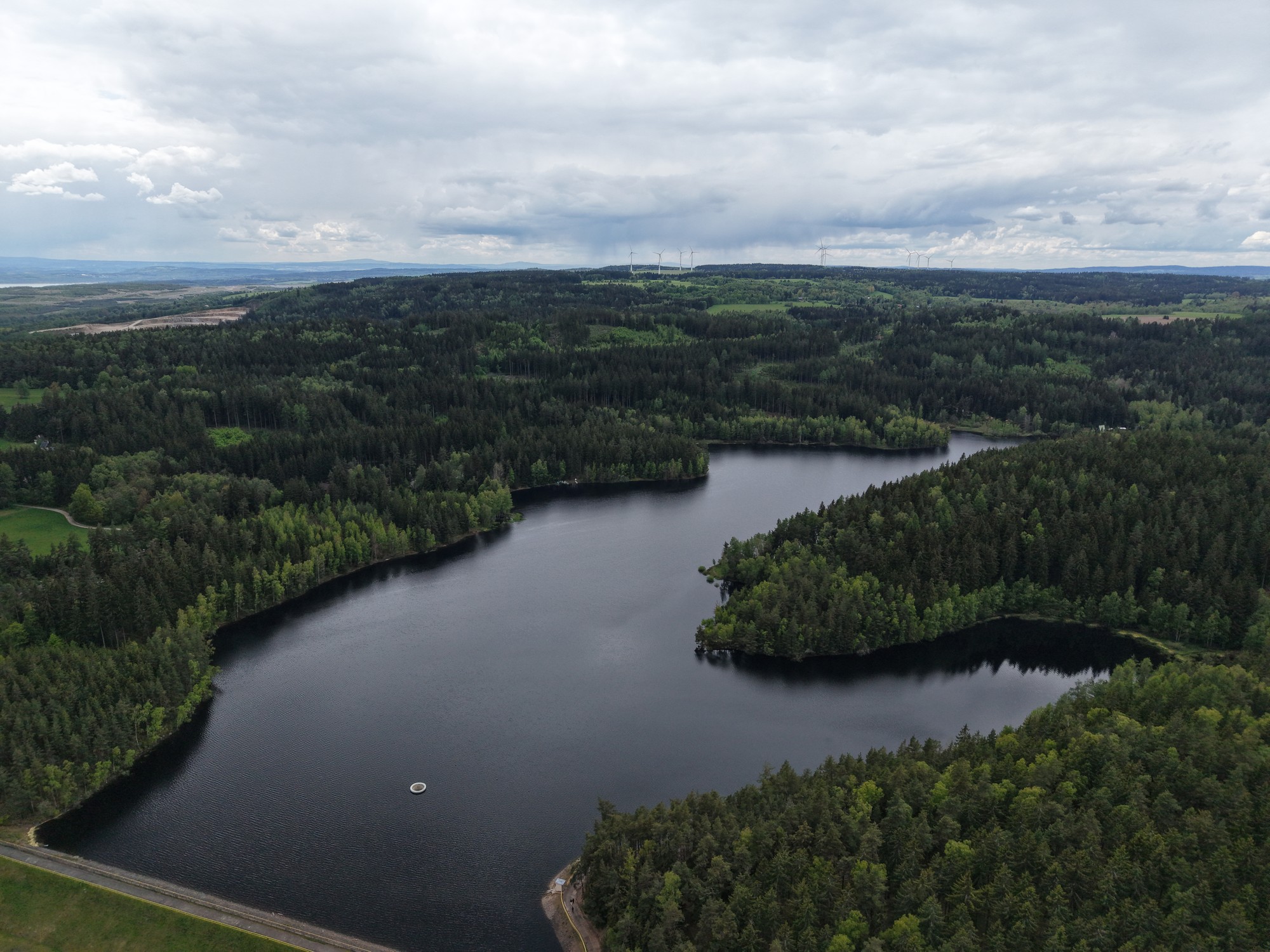 Letecký pohled na přehradu obklopenou lesem — DJI Air 3S