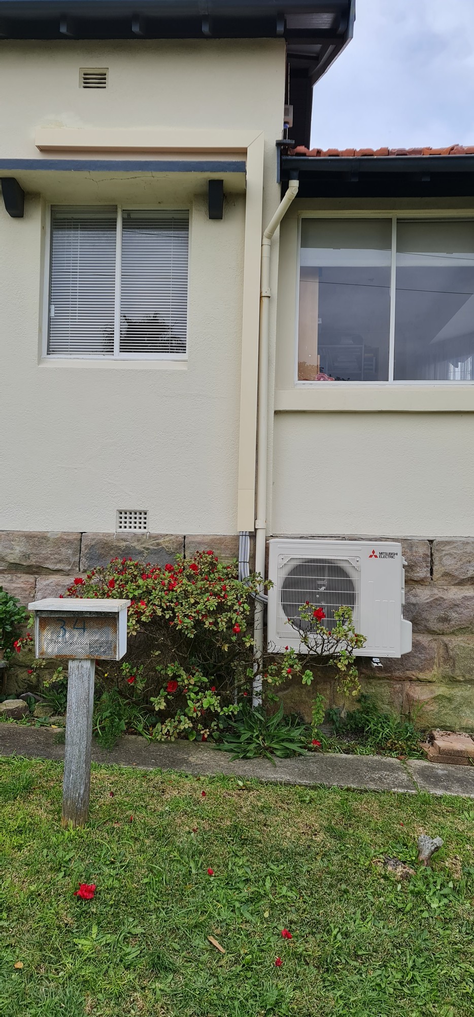 Mitsubishi Electric outdoor condenser unit installed on exterior wall of residential home