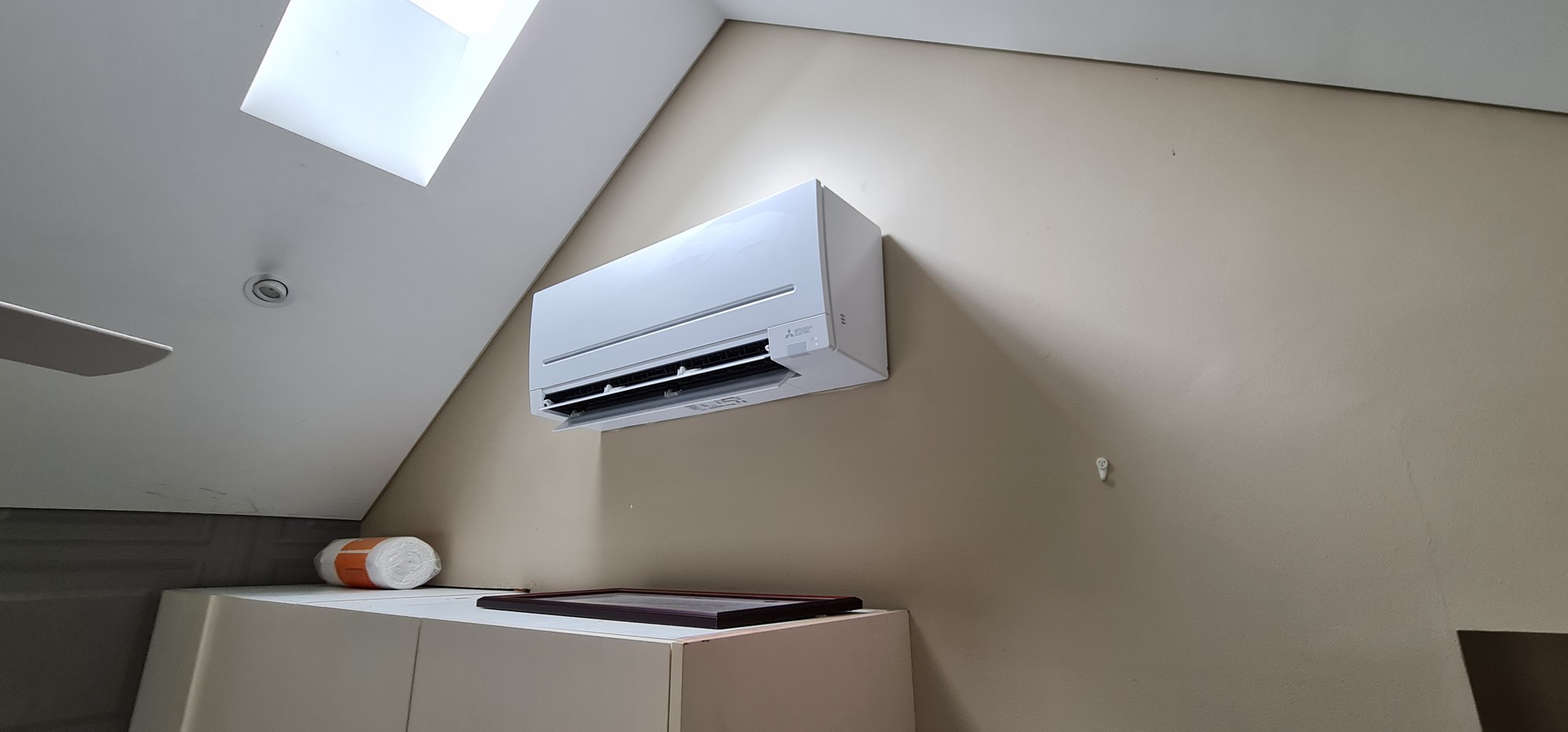 Mitsubishi Electric split system indoor unit installed in attic room with skylight