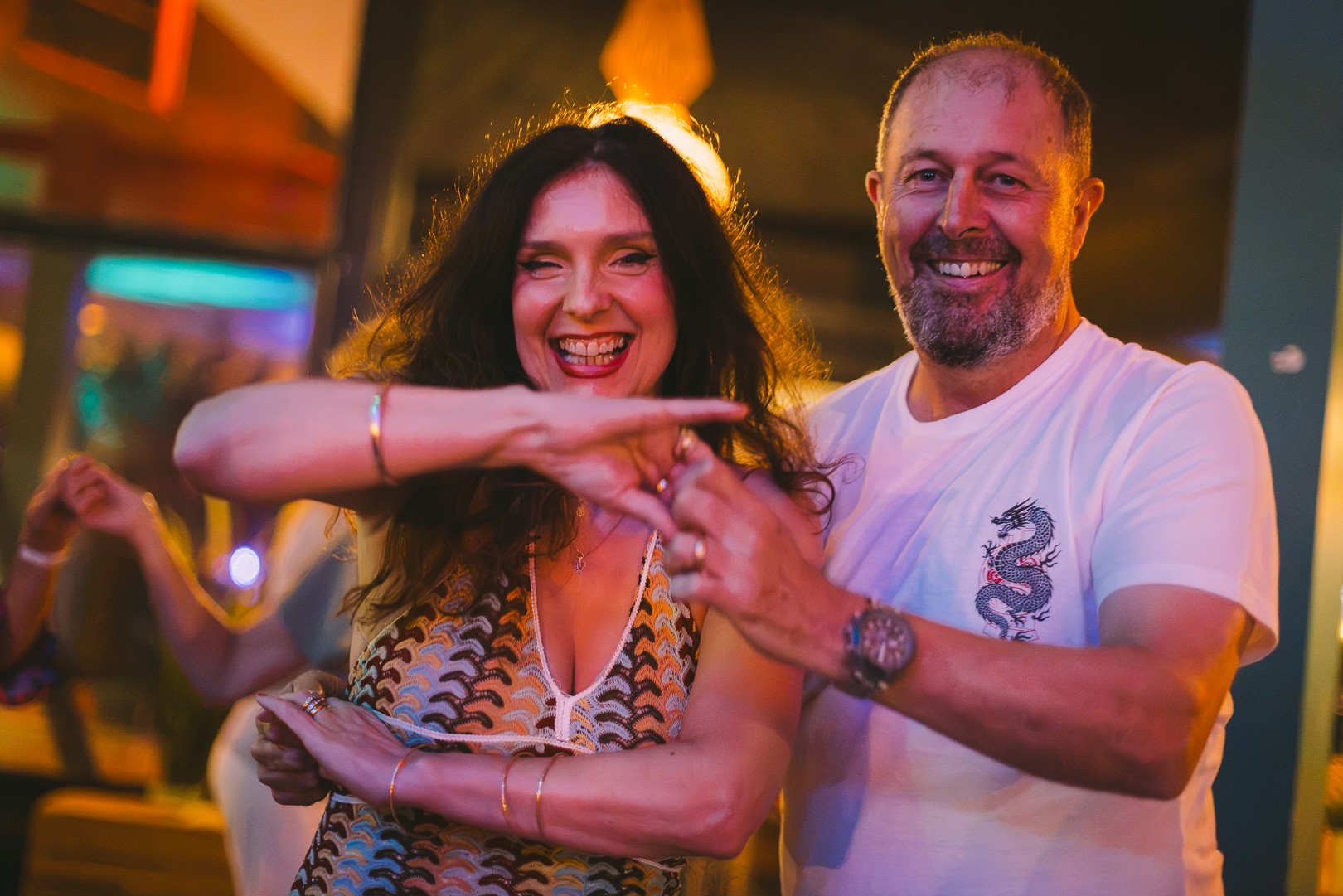 Two dancers laughing and pointing playfully at the camera
