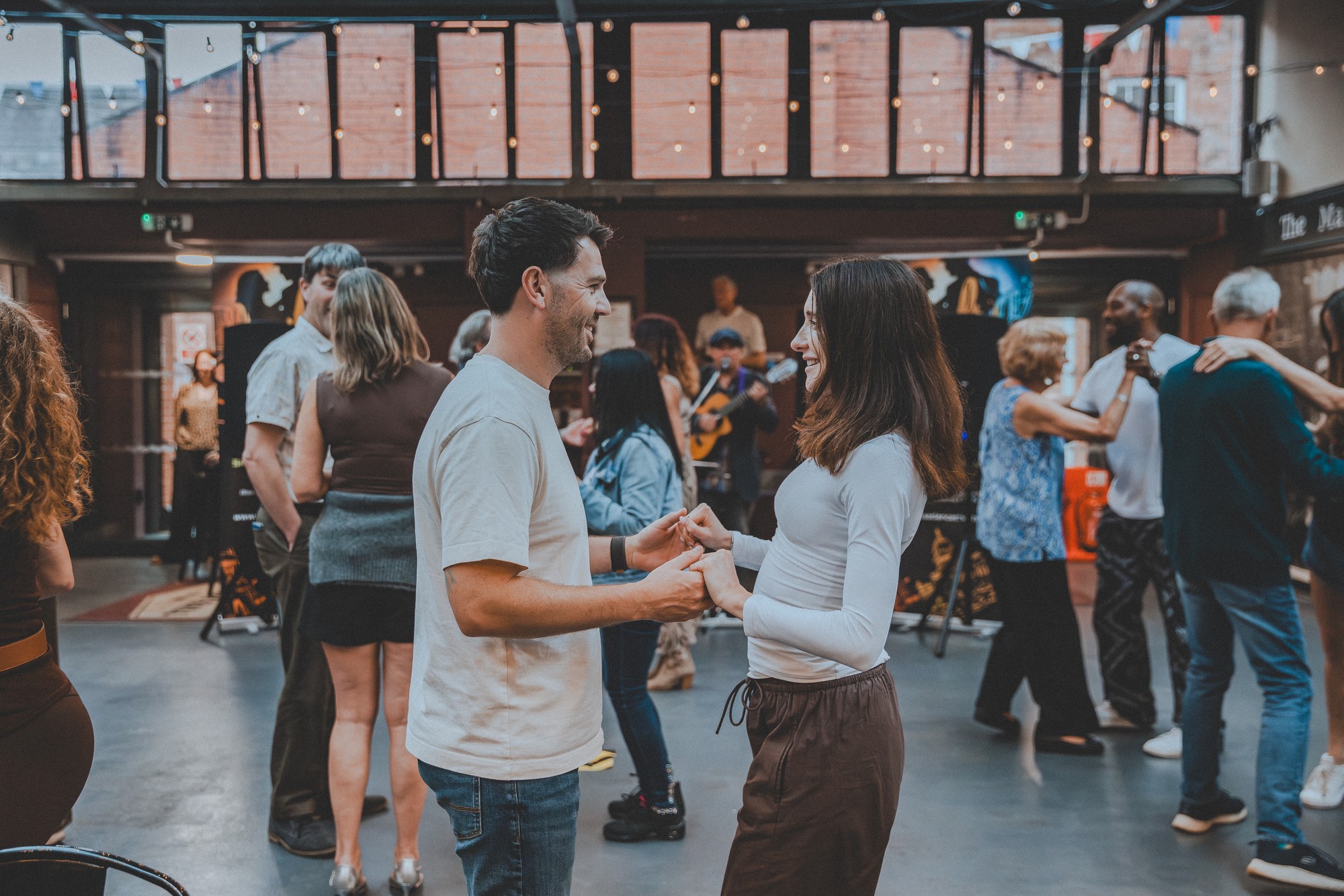 Smiling couple holding hands and dancing at a salsa social night
