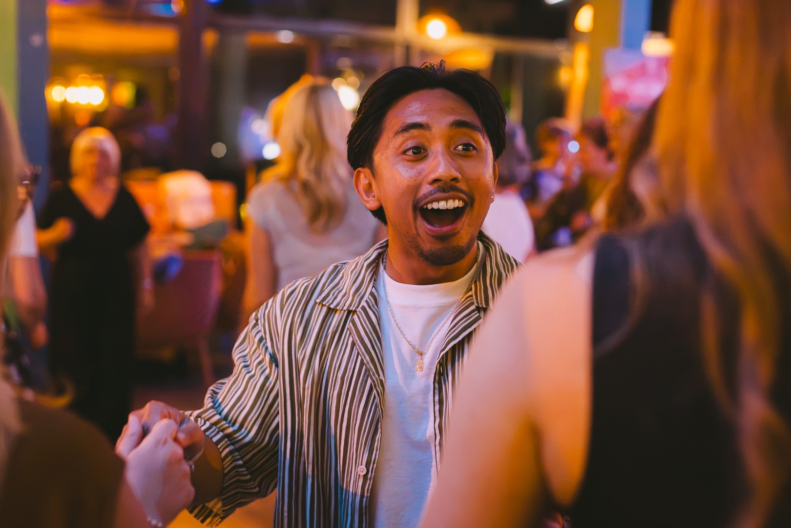A delighted dancer holding his partner’s hand mid-move