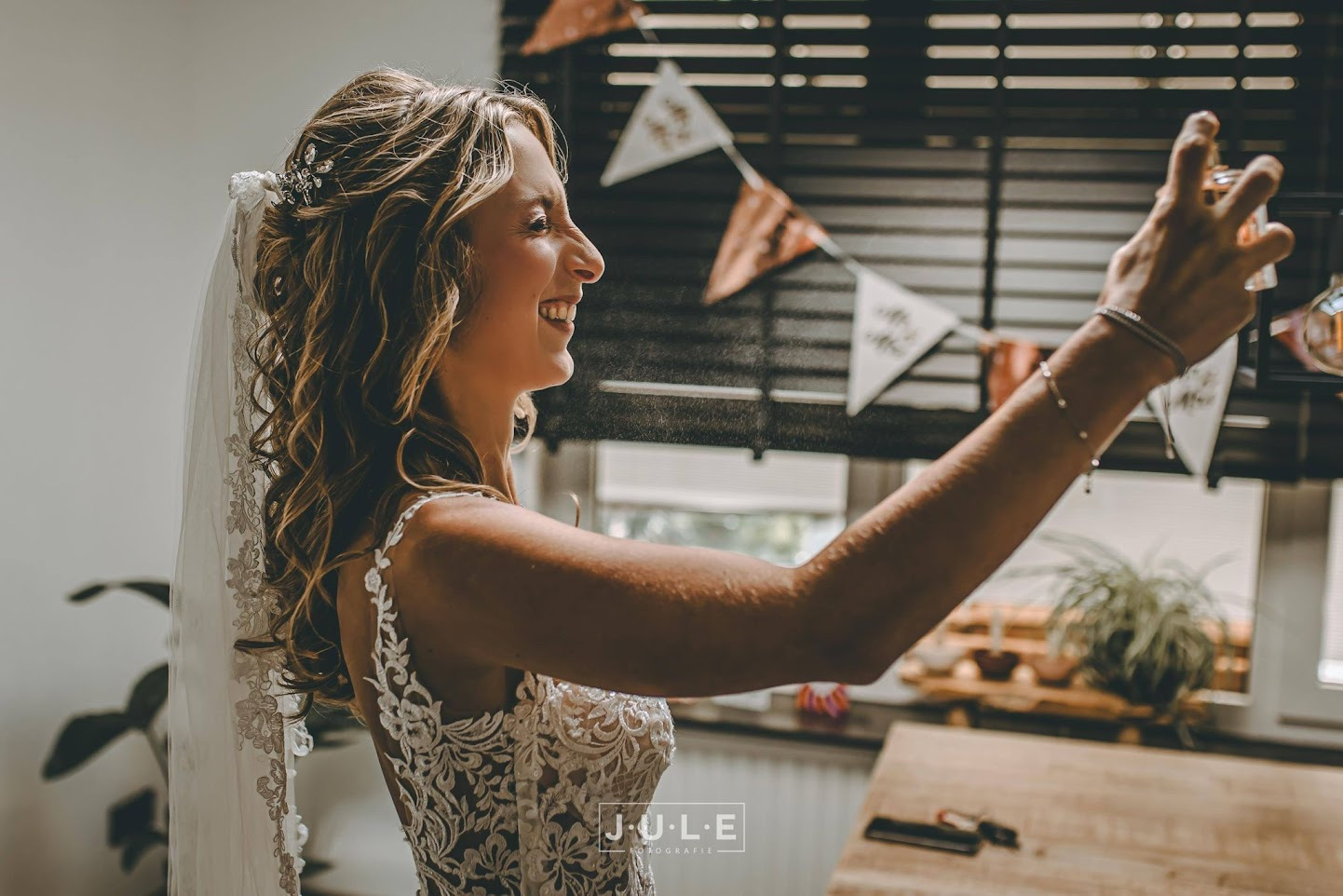 Bruidsstylist plaatst bloemen in het gekrulde bruidskapsel