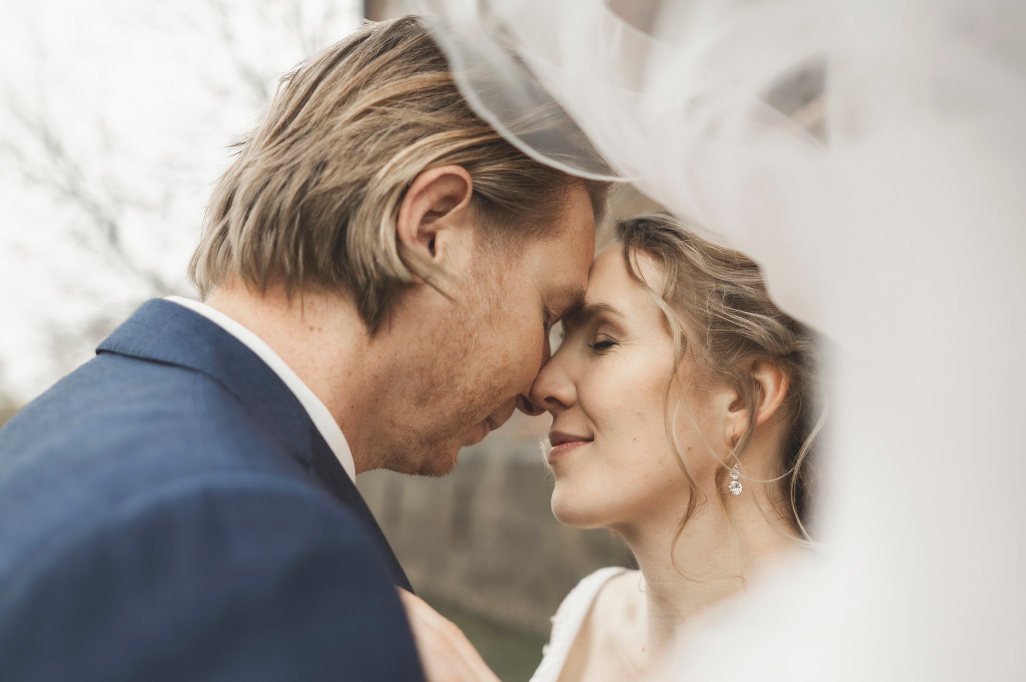 Bruid in haar jurk voor het raam tijdens de voorbereidingen