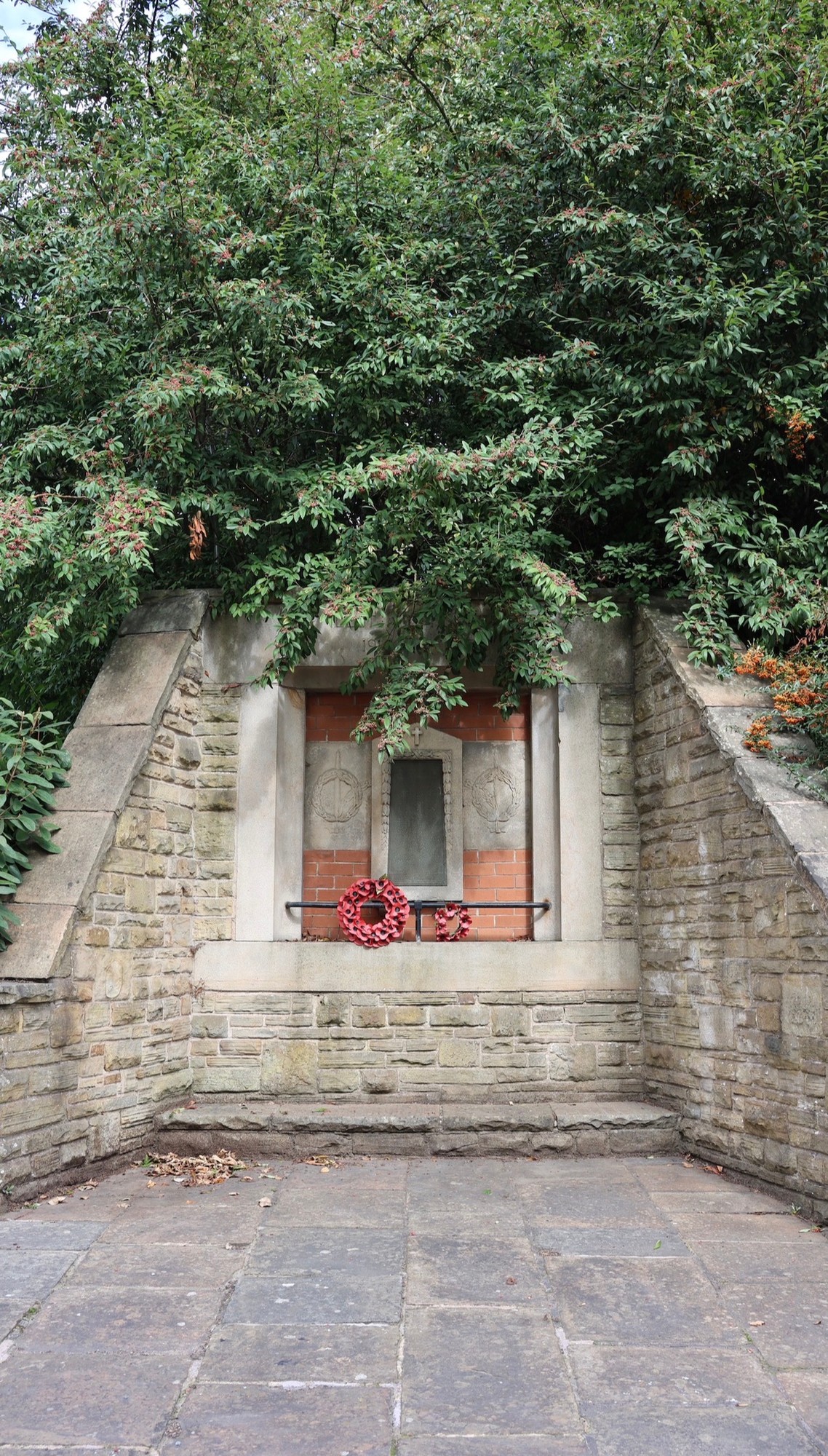 Memorial stone with its inscription clearly visible among branches