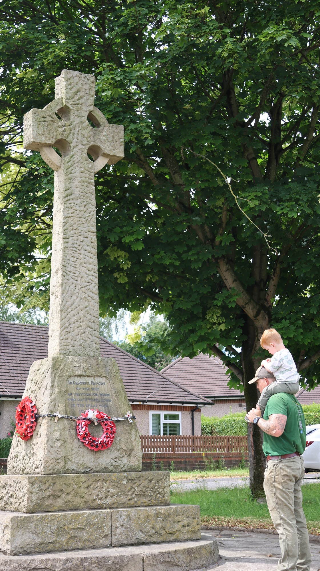 Volunteer mowing the grass around a memorial to keep it cared for