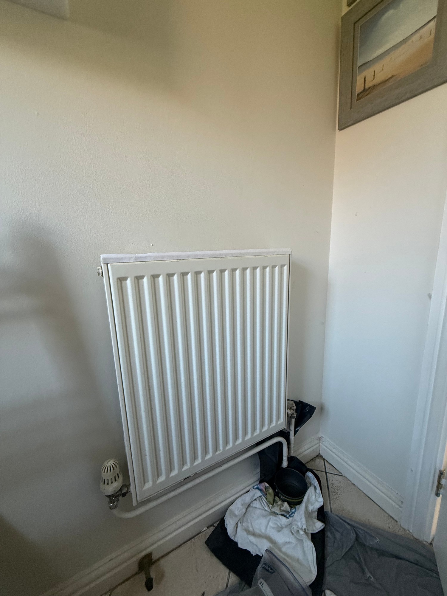 Old white panel radiator removed from a bathroom wall before work