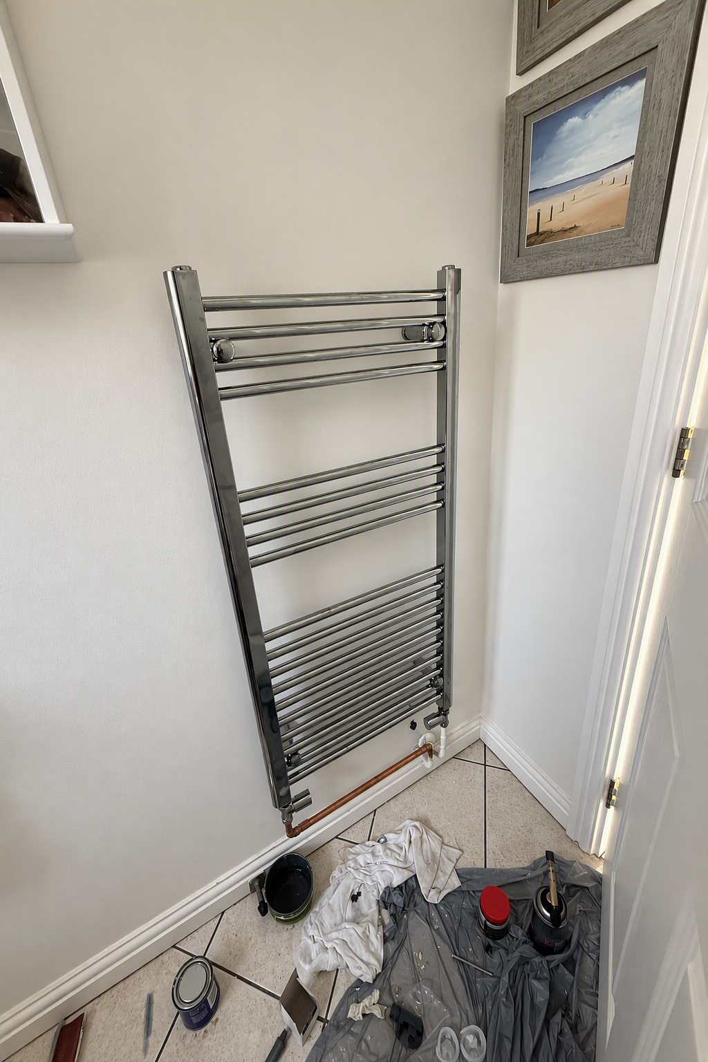 New chrome heated towel rail fitted on the same bathroom wall