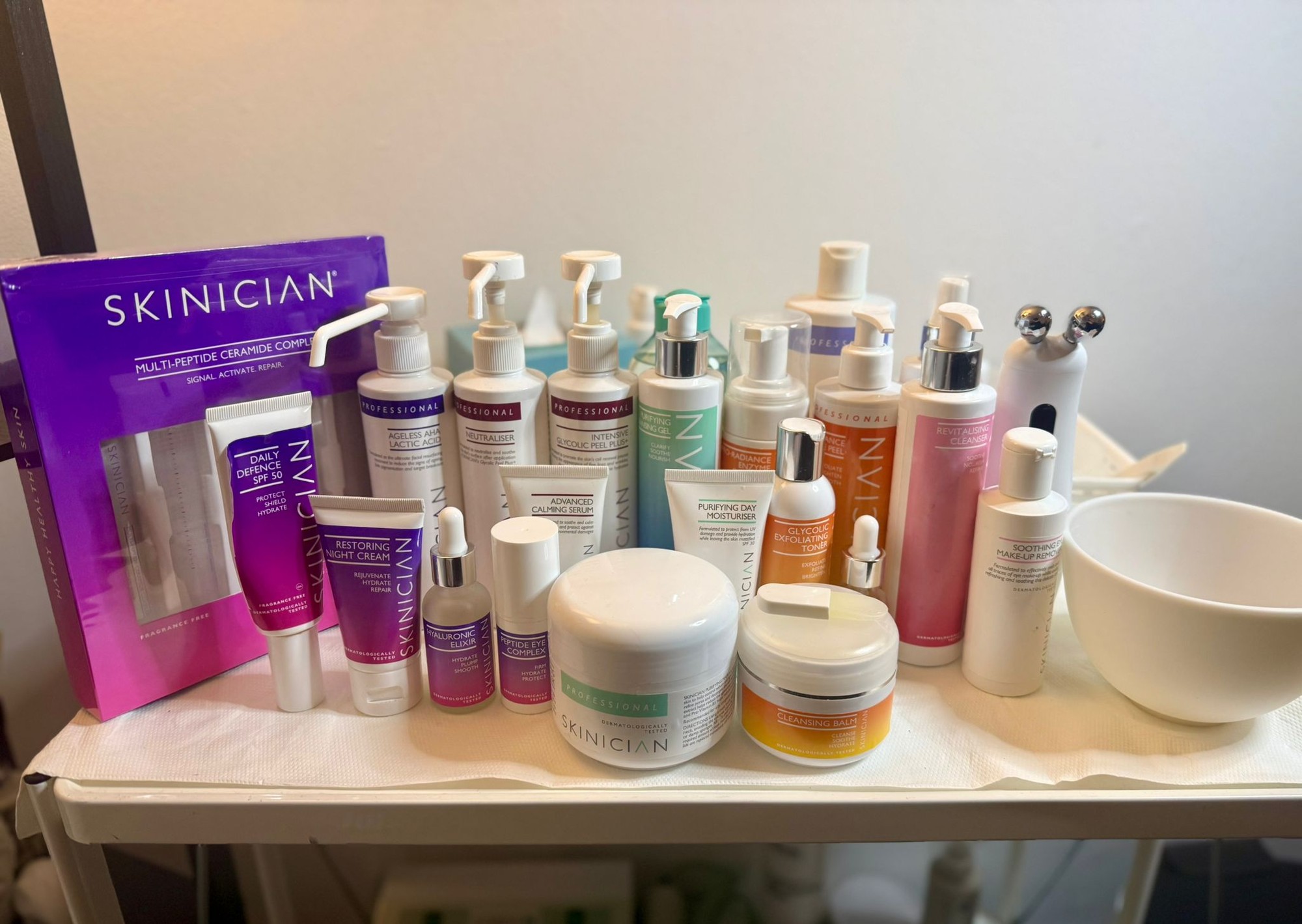Skinician skincare products including glycolic toner, hyaluronic elixir, retinol balm, and moisture gel