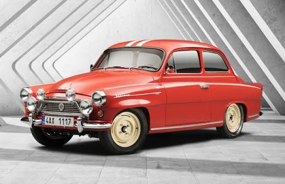 Červená klasická Škoda Octavia s bílým pruhem v industriálním prostředí