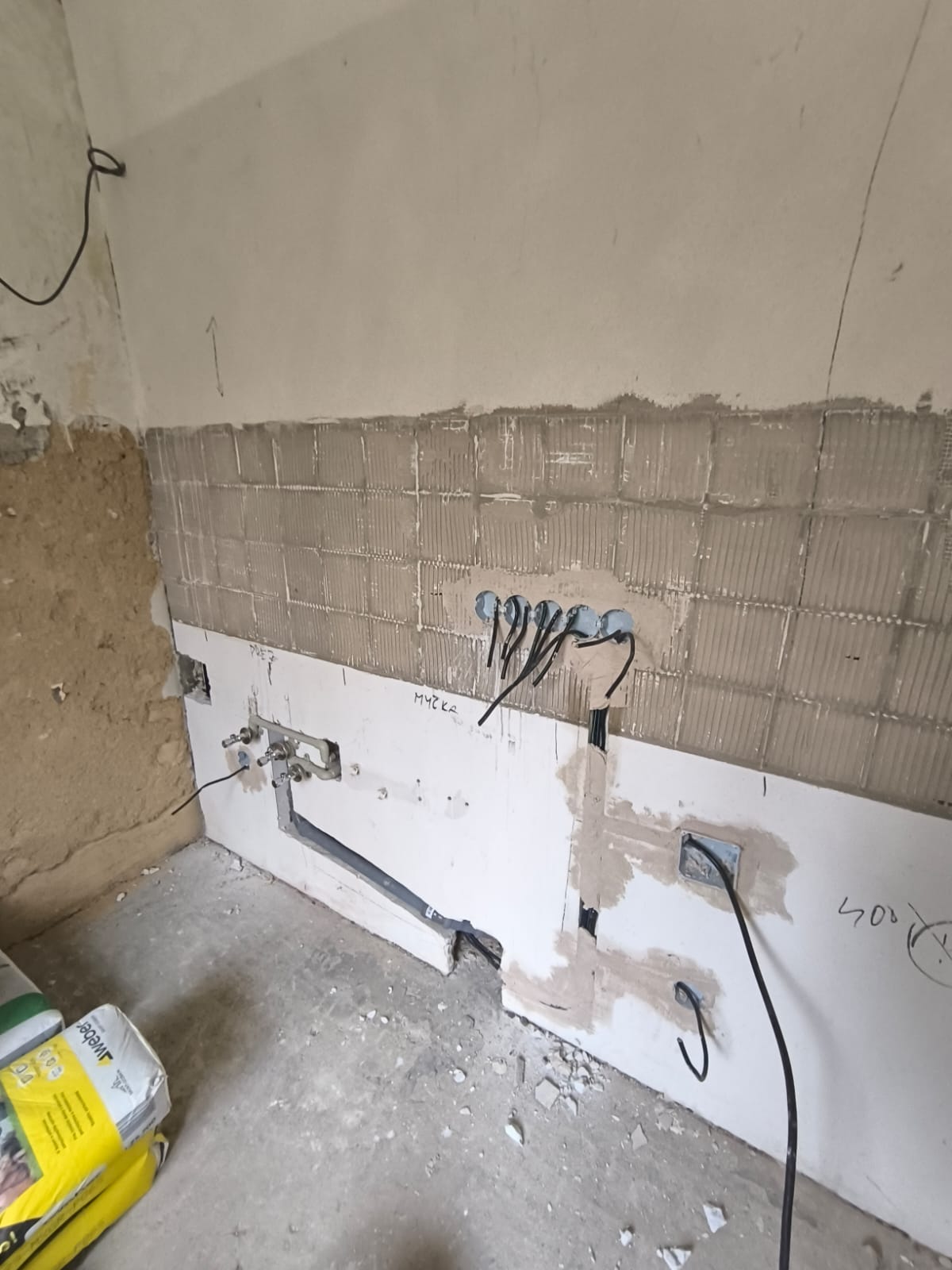 Hrubá montáž kuchyně — nový obklad, rozvody vody a elektro v nových pozicích.