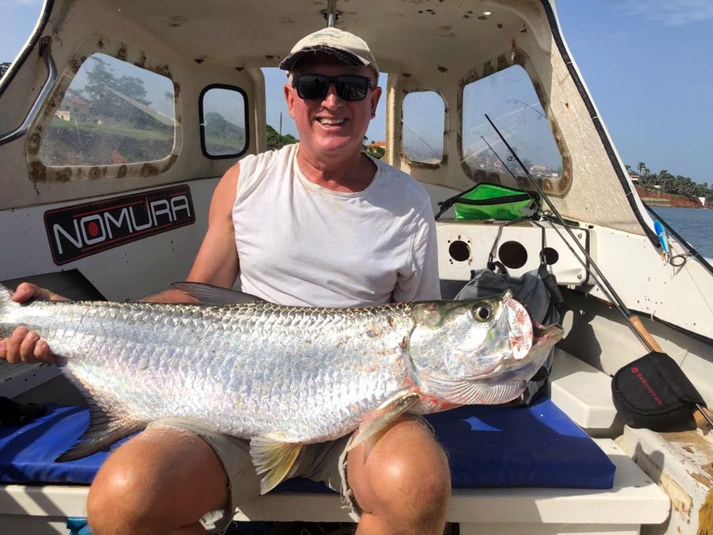 Lystfisker med to store trevally-fisk over båden