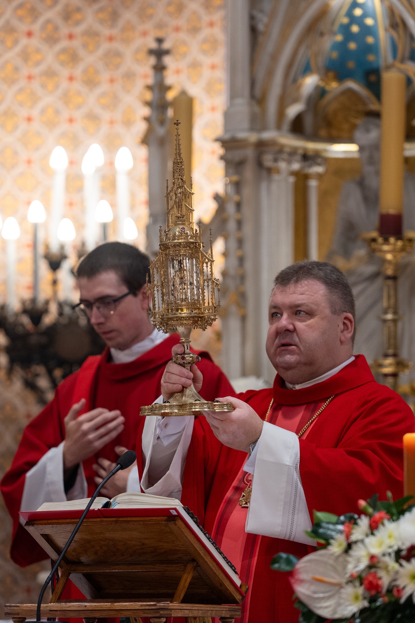 Duchovní v červených ornátách během bohoslužby