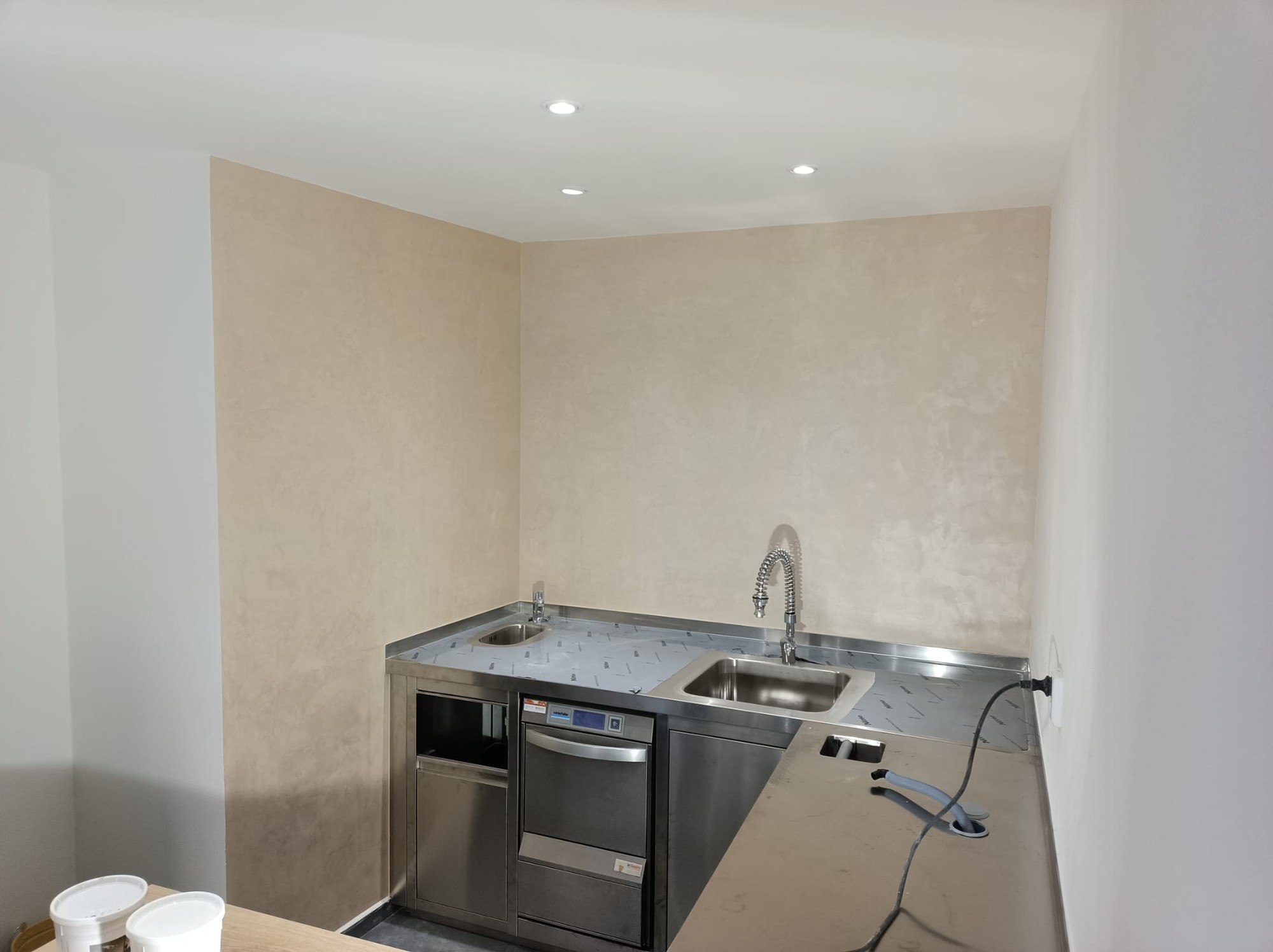 Kuchyně se světlými mikrocementovými stěnami