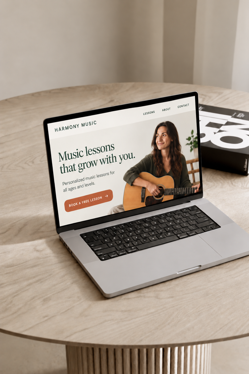 Laptop displaying a music teacher website on a light wooden table