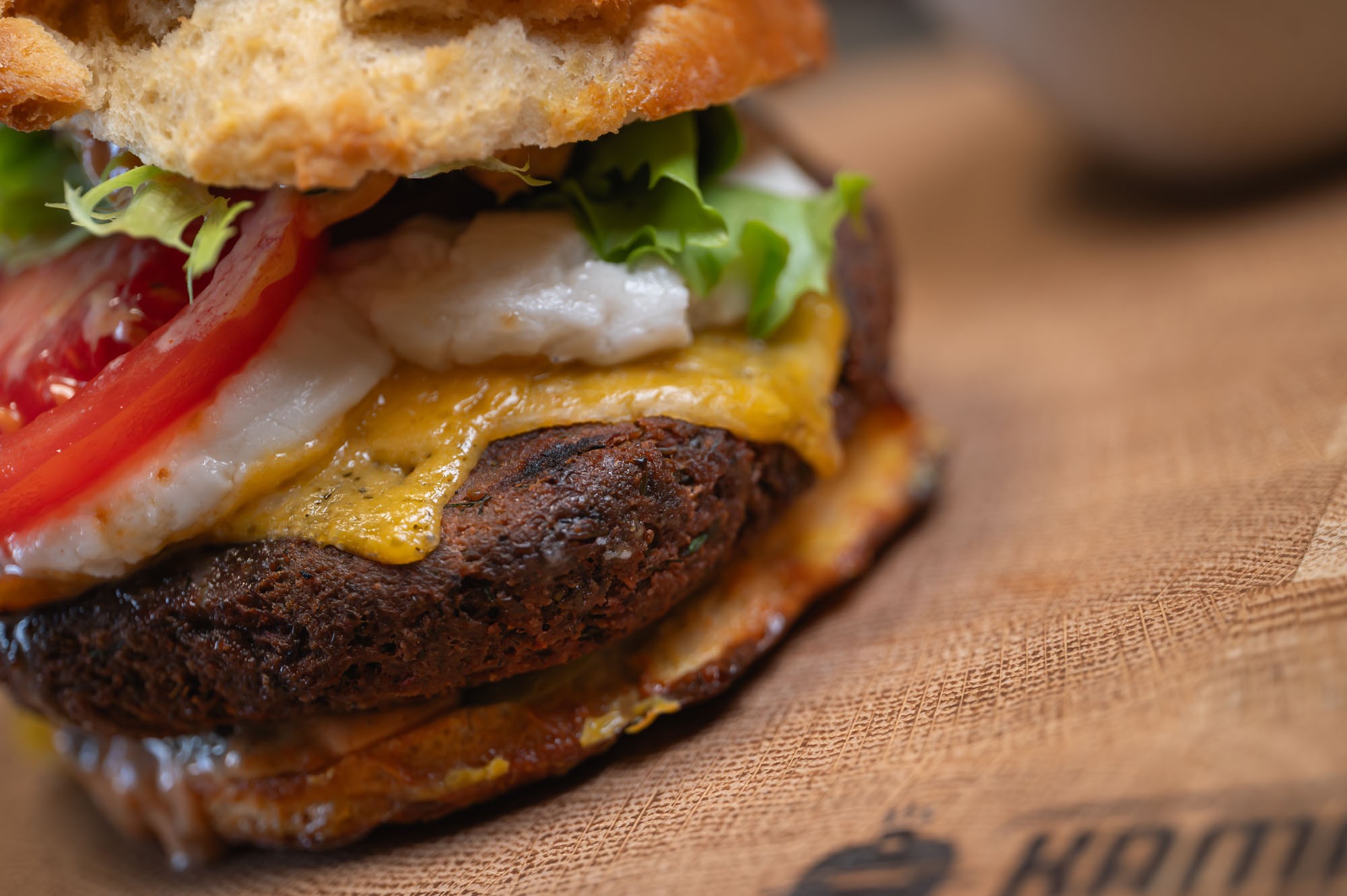 Veggie Burger v priereze — detail plného burgeru na papieri Kamado